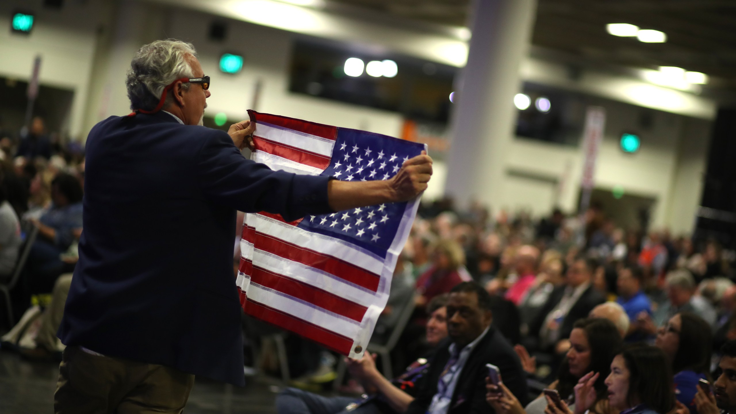 An attendee carries an American flag during the California Democrats 2019 State Convention at the Moscone Center on June 1, 2019, in San Francisco. (Credit: Justin Sullivan/Getty Images)