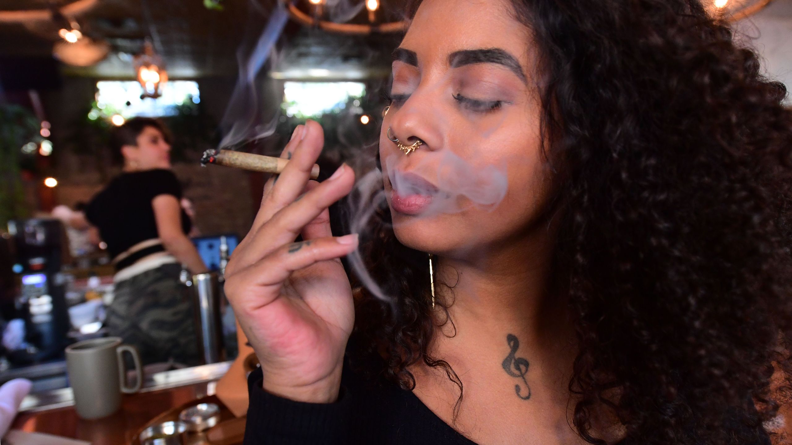 Kush Doleo smokes a joint at the Lowell Cafe in West Hollywood on Sept. 30, 2019, a day before its official opening. (Credit: Frederic J. Brown / AFP / Getty Images)