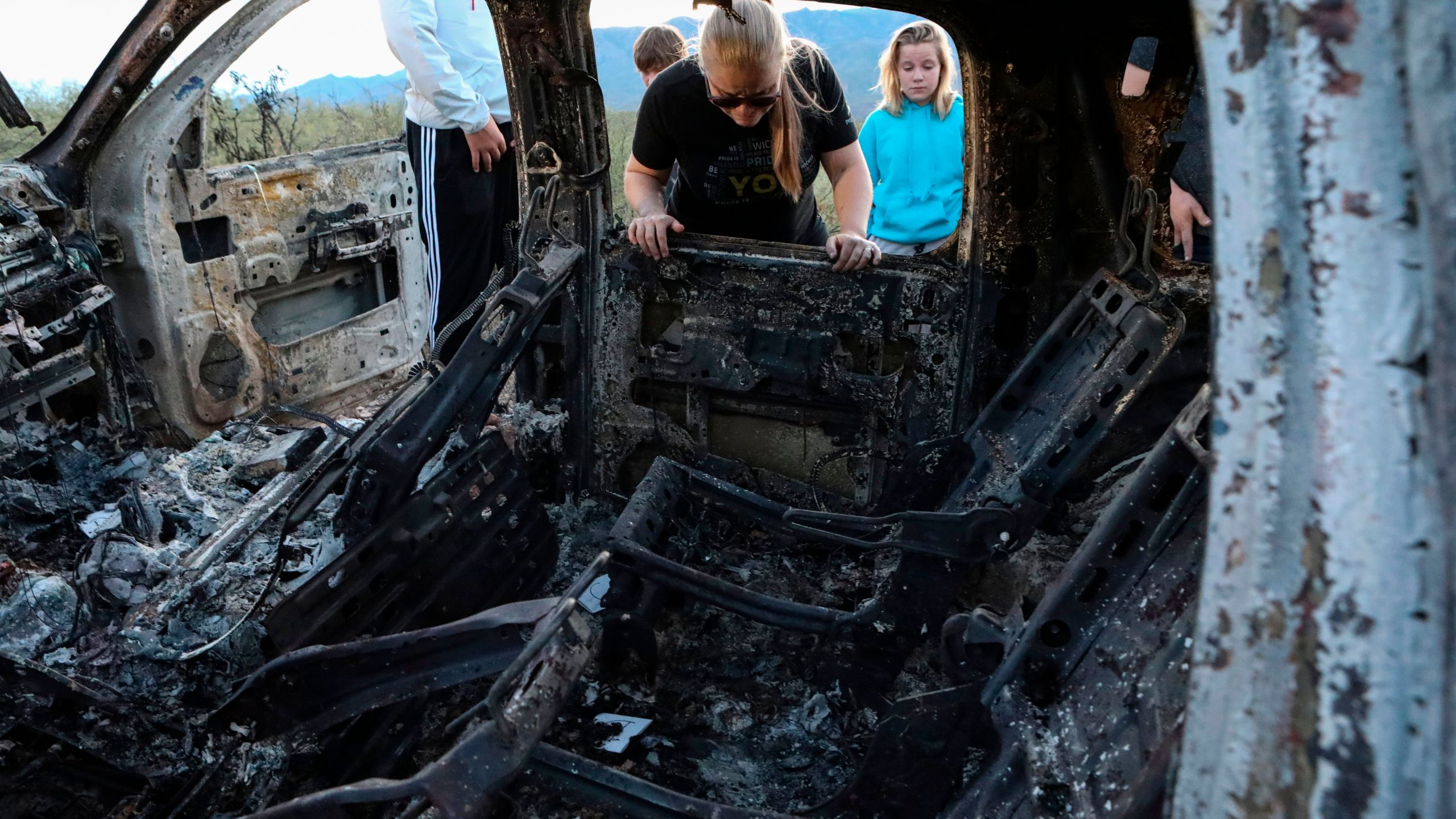 Members of the LeBaron family view the burned car where their relatives were killed and burned during an ambush in Bavispe, Sonora mountains, Mexico, on Nov. 5, 2019. (Credit: Herika Martinez / AFP / Getty Images)