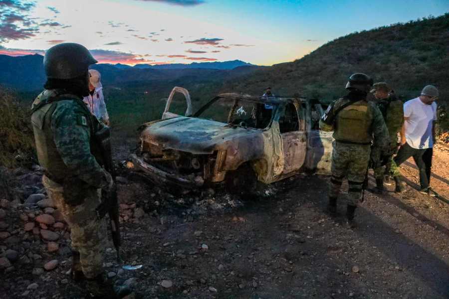 People stand near the burned car where members of the LeBaron family were killed and burned during an ambush in Bavispe, Sonora mountains, Mexico, on Nov. 5, 2019. (Credit: Herika Martinez / AFP / Getty Images)