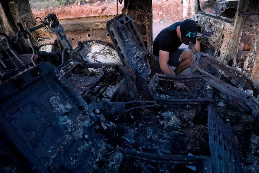 A member of thA member of the LeBaron family looks at the burned car where some of nine relatives were killed and burned during an ambush in Bavispe, Sonora mountains, Mexico, on Nov. 5, 2019. (Herika Martinez / AFP / Getty Images) LeBaron family looks at the burned car where some of nine relatives were killed and burned during an ambush in Bavispe, Sonora mountains, Mexico, on Nov. 5, 2019. (Credit: Herika Martinez / AFP / Getty Images)