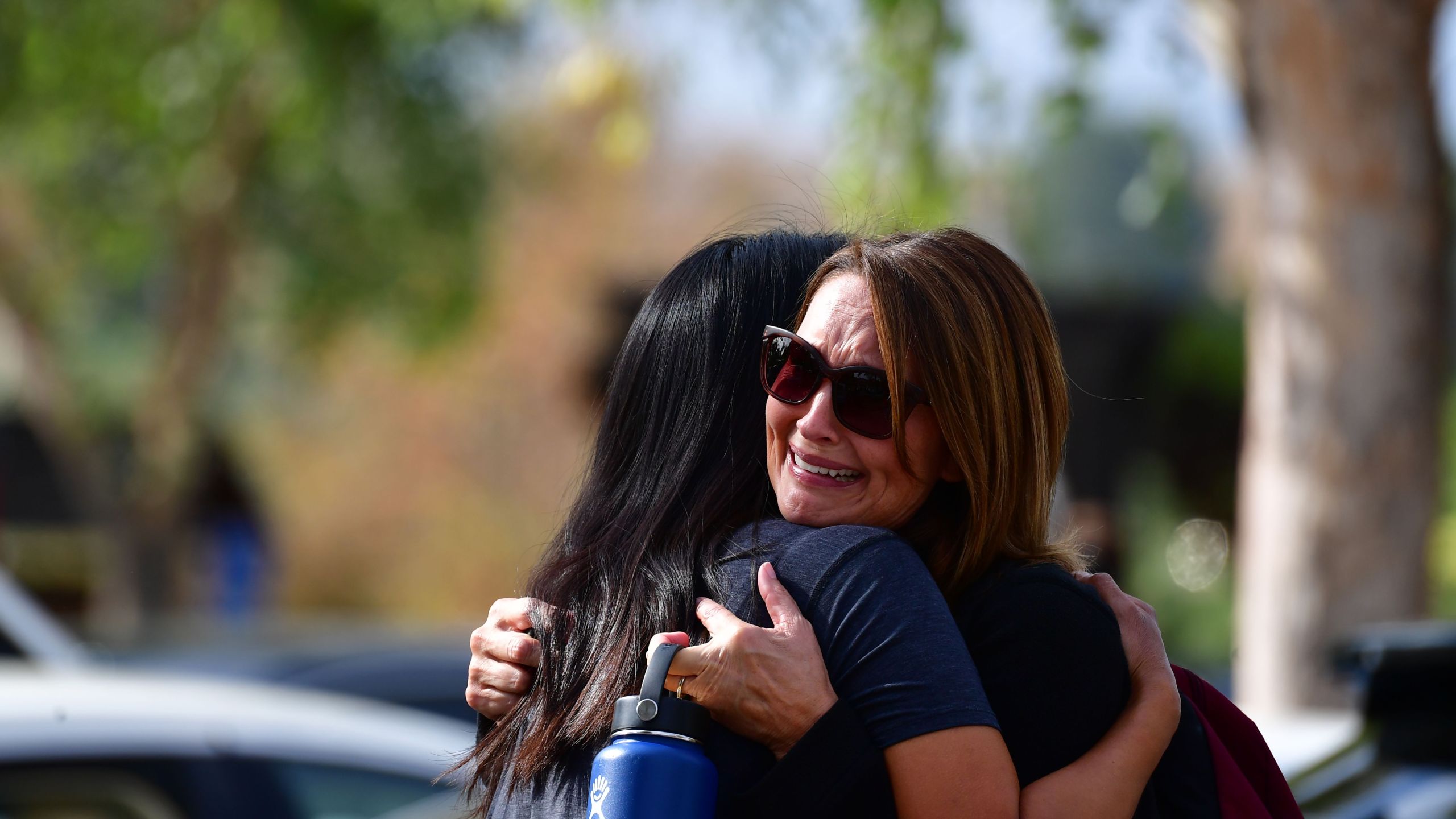 Women embrace in Central Park after a shooting at Saugus High School in Santa Clarita on Nov. 14, 2019. (Credit: FREDERIC J. BROWN/AFP via Getty Images)