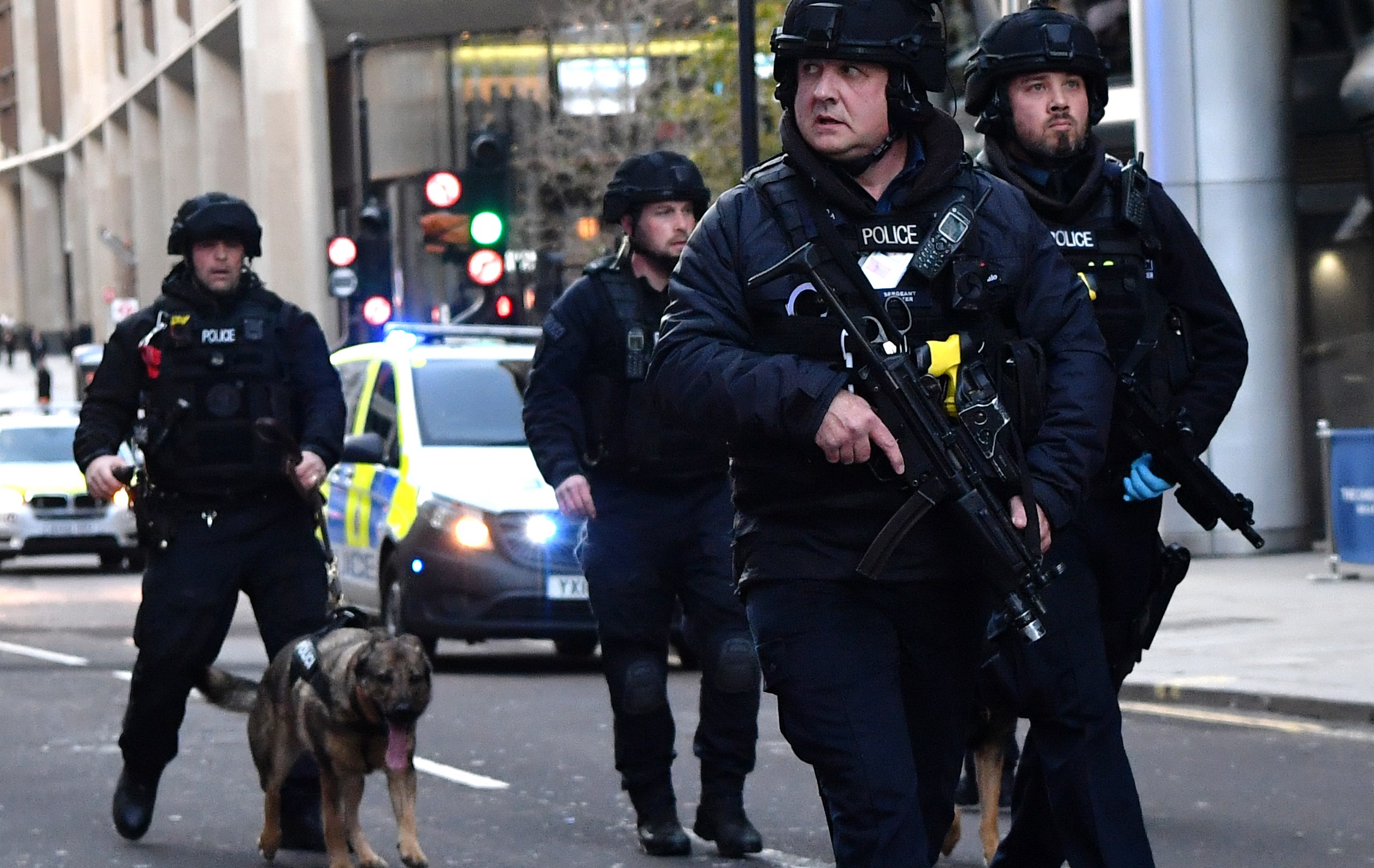 Armed police with dogs patrol along Cannon Street in central London after a stabbing attack on the London Bridge on Nov. 29, 2019. (Credit: Ben Stansall / AFP / Getty Images)