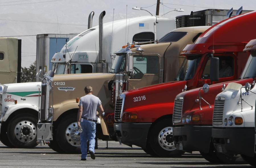 A trucker walks back to his truck at a fueling depot in Oak Hills on April 1, 2008. (Credit: Robyn Beck/AFP via Getty Images)