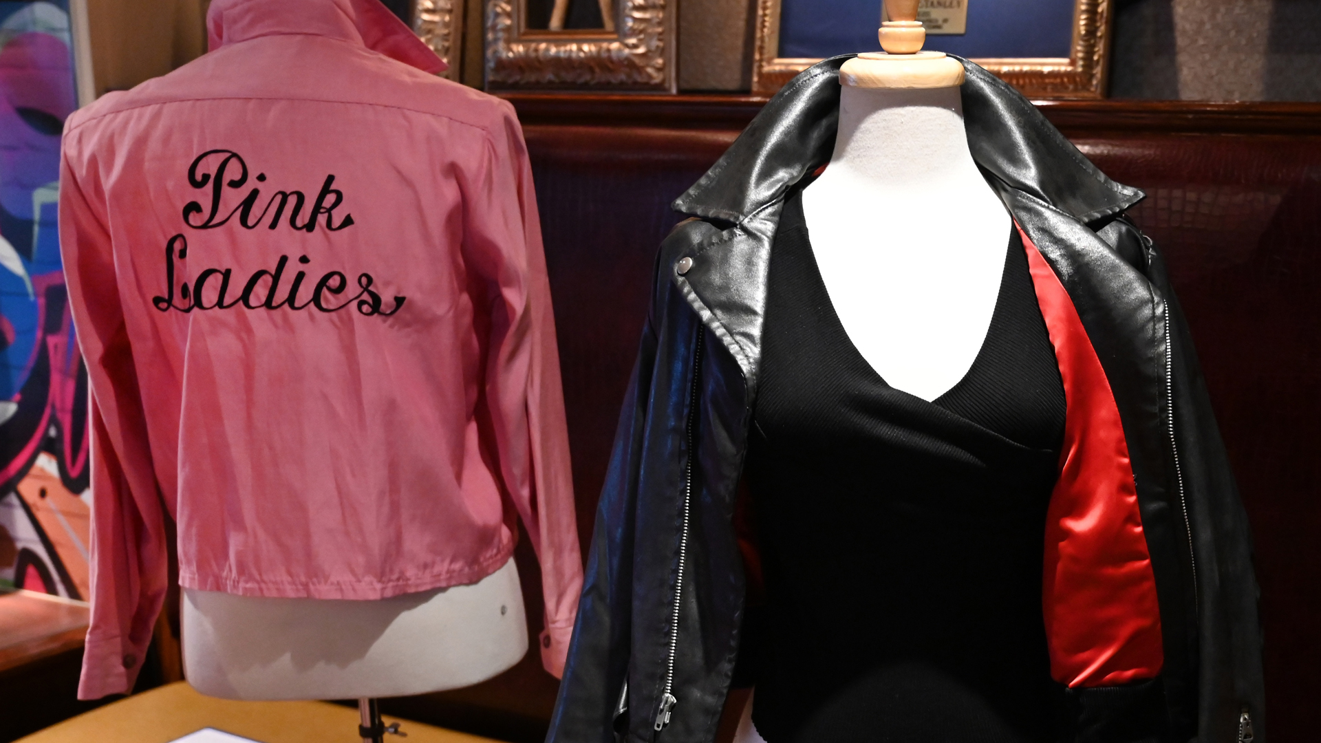 Olivia Newton-John's famous black leather jacket worn in the blockbuster film "Grease" and her Grease "Pink Ladies" jacket worn in the film are shown during a Julien's Auctions press preview at Hard Rock Cafe in New York on October 16, 2019.(Credit: Timothy A. Clary/AFP via Getty Images)