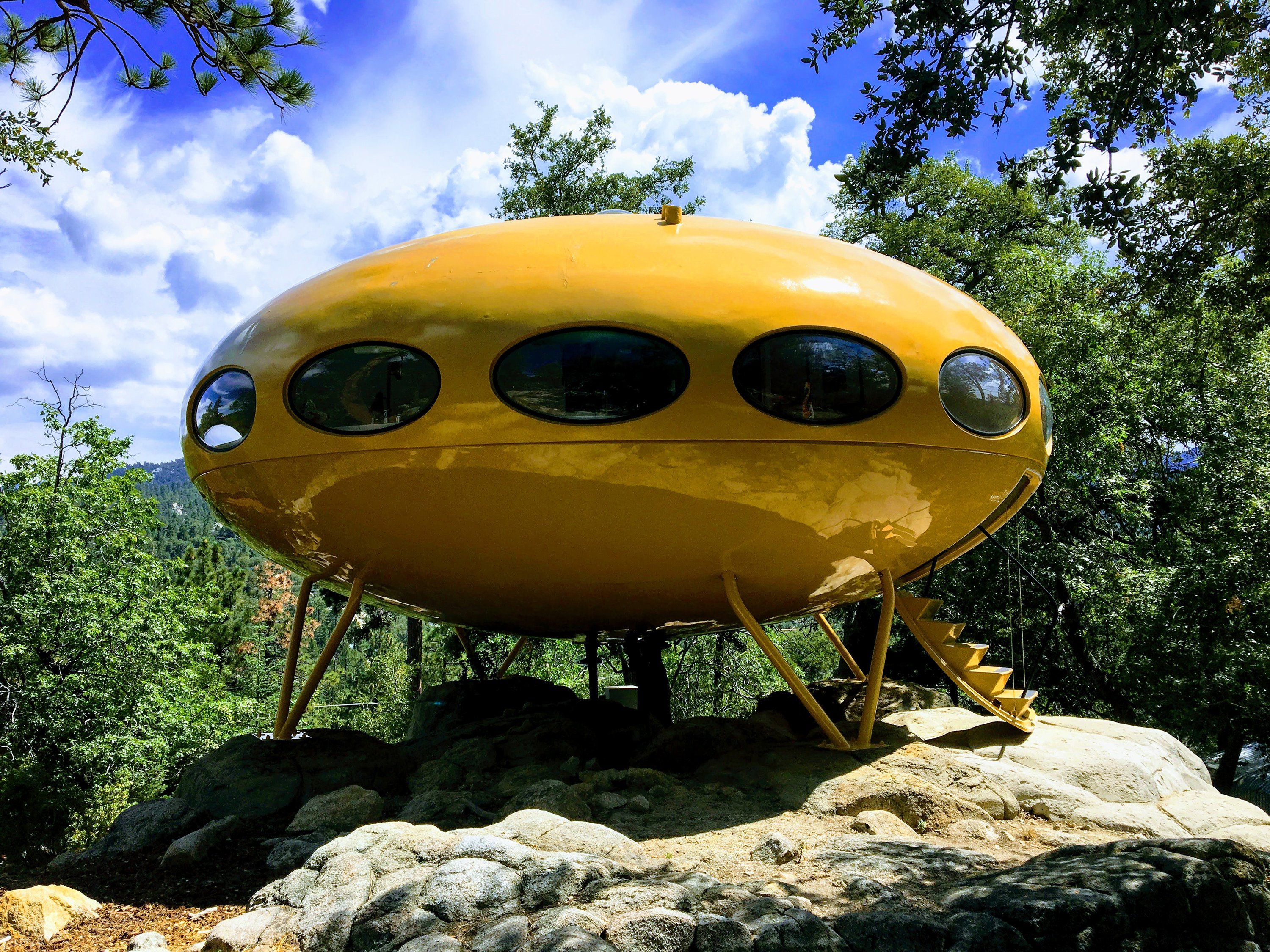 The harvest-gold flying saucer perched on a rocky ledge high above Idyllwild, California, is a Futuro house. (Credit: CNN)