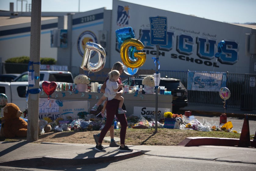 Kim Segal, 43, and her children pay their respects Monday at a memorial at Saugus High School, where two students were killed in a shooting and three others were wounded. (Credit: Jason Armond / Los Angeles Times)