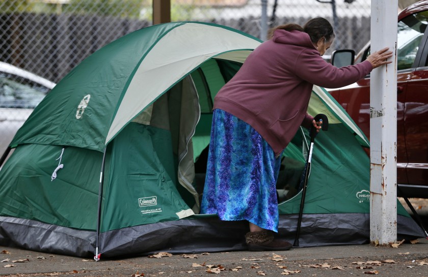 Sue Smith steadies herself as she gets in her tent at a wildfire evacuation center in 2015. (Credit: Don Bartletti / Los Angeles Times)