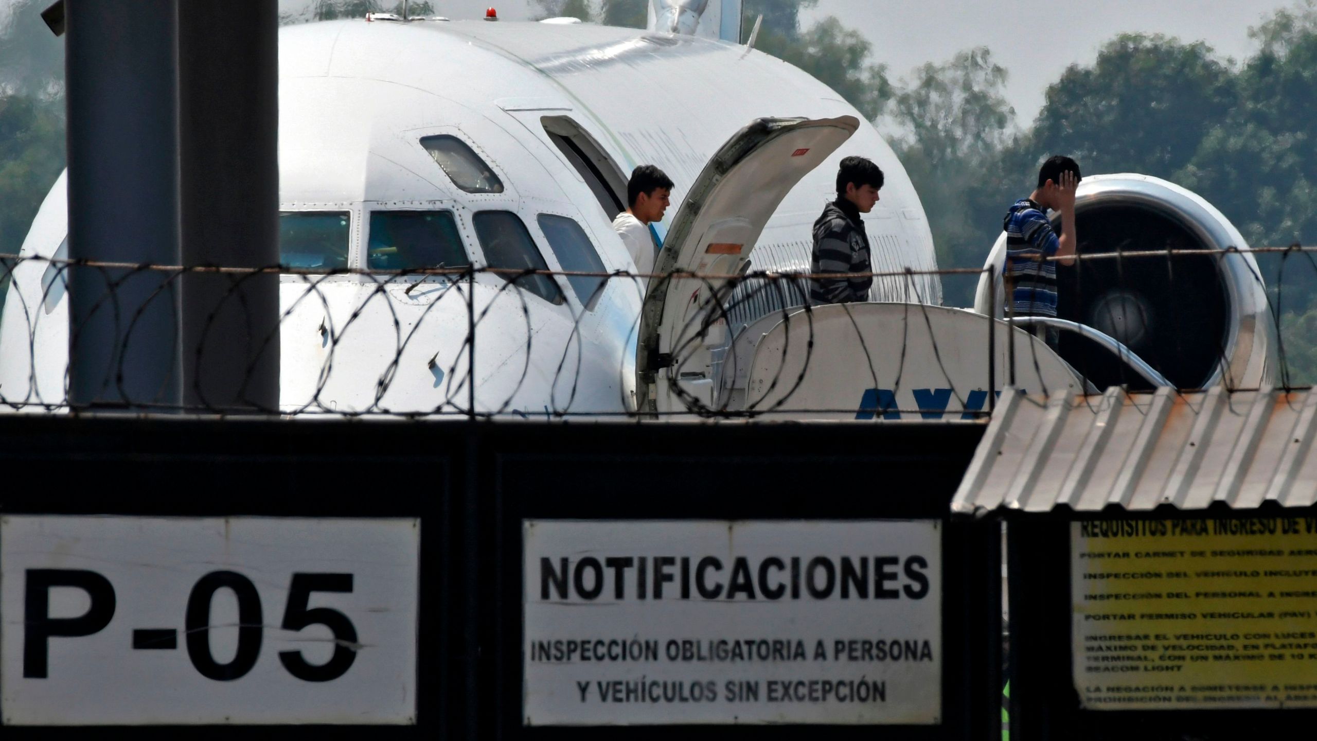 Honduran migrants get off a plane as they arrive at the Ramon Villeda Morales airport in San Pedro Sula on April 11, 2019, after being deported from the U.S. (Credit: ORLANDO SIERRA/AFP via Getty Images)