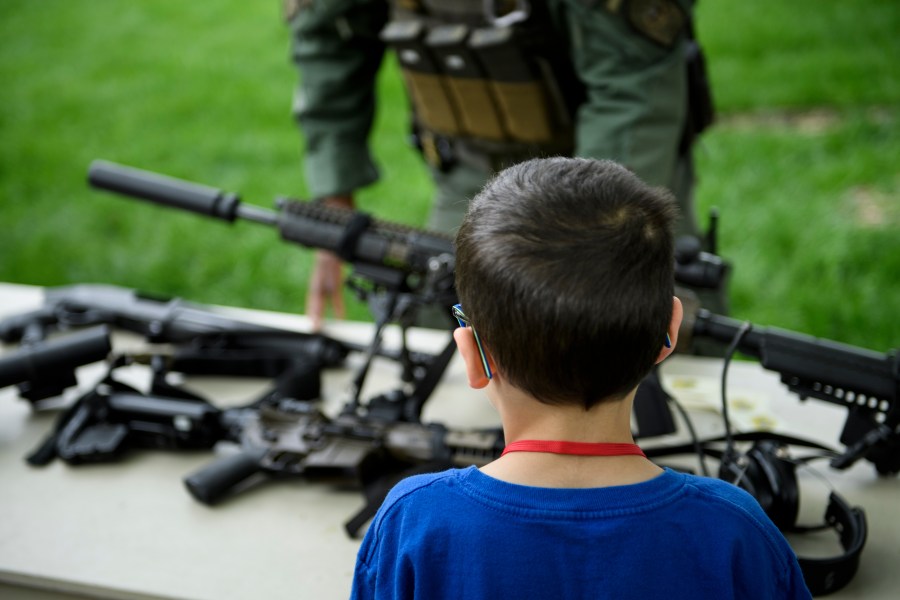 A child looks at a rifle during a demonstration for "Take Your Child to Work Day" at the Pentagon April 25, 2019, in Washington, D.C. (Credit: BRENDAN SMIALOWSKI/AFP via Getty Images)