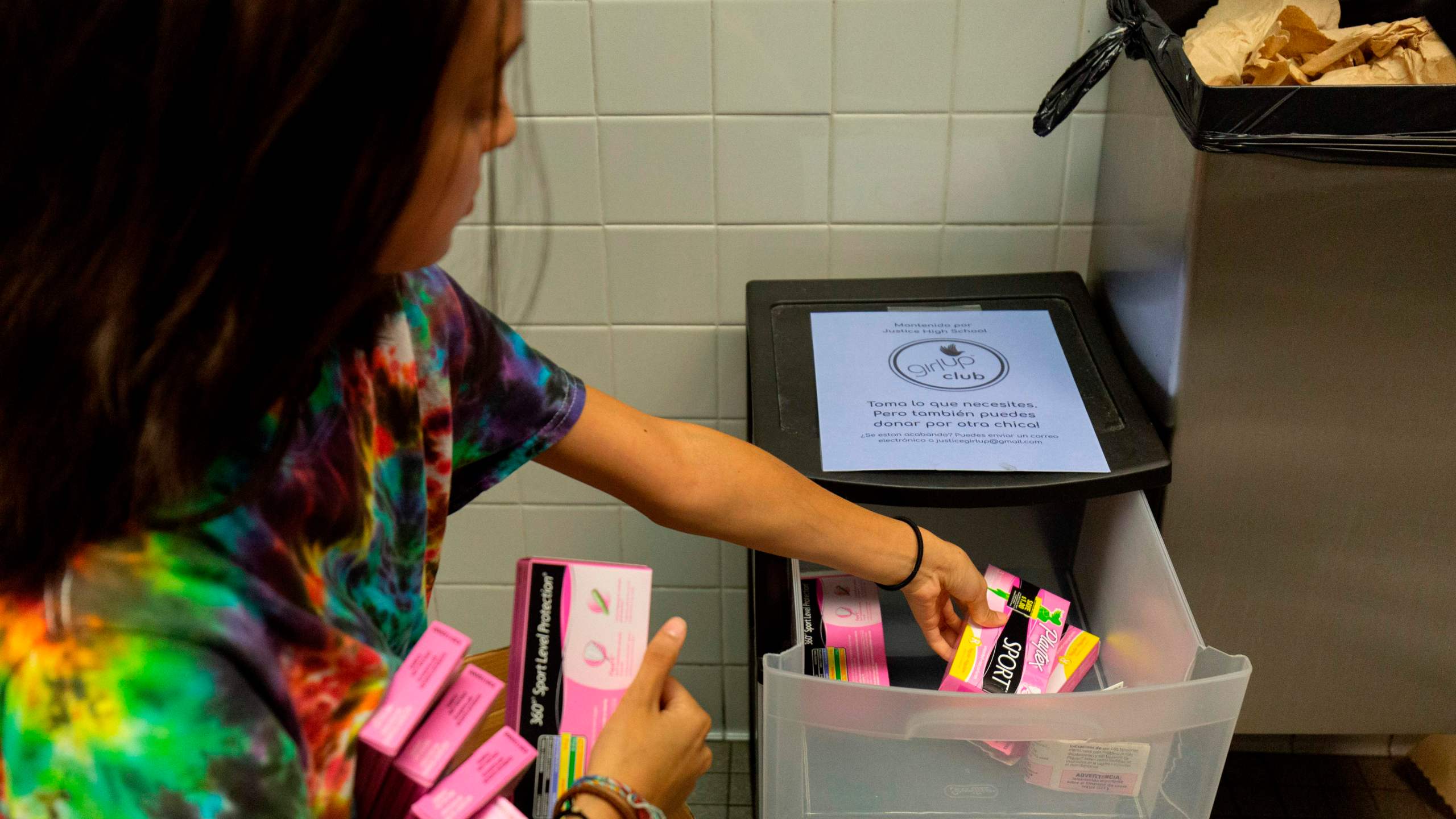 A student stocks a school bathroom with free pads and tampons to push for menstrual equity, at Justice High School in Falls Church, Virginia, on Sept. 11, 2019. (ALASTAIR PIKE/AFP via Getty Images)