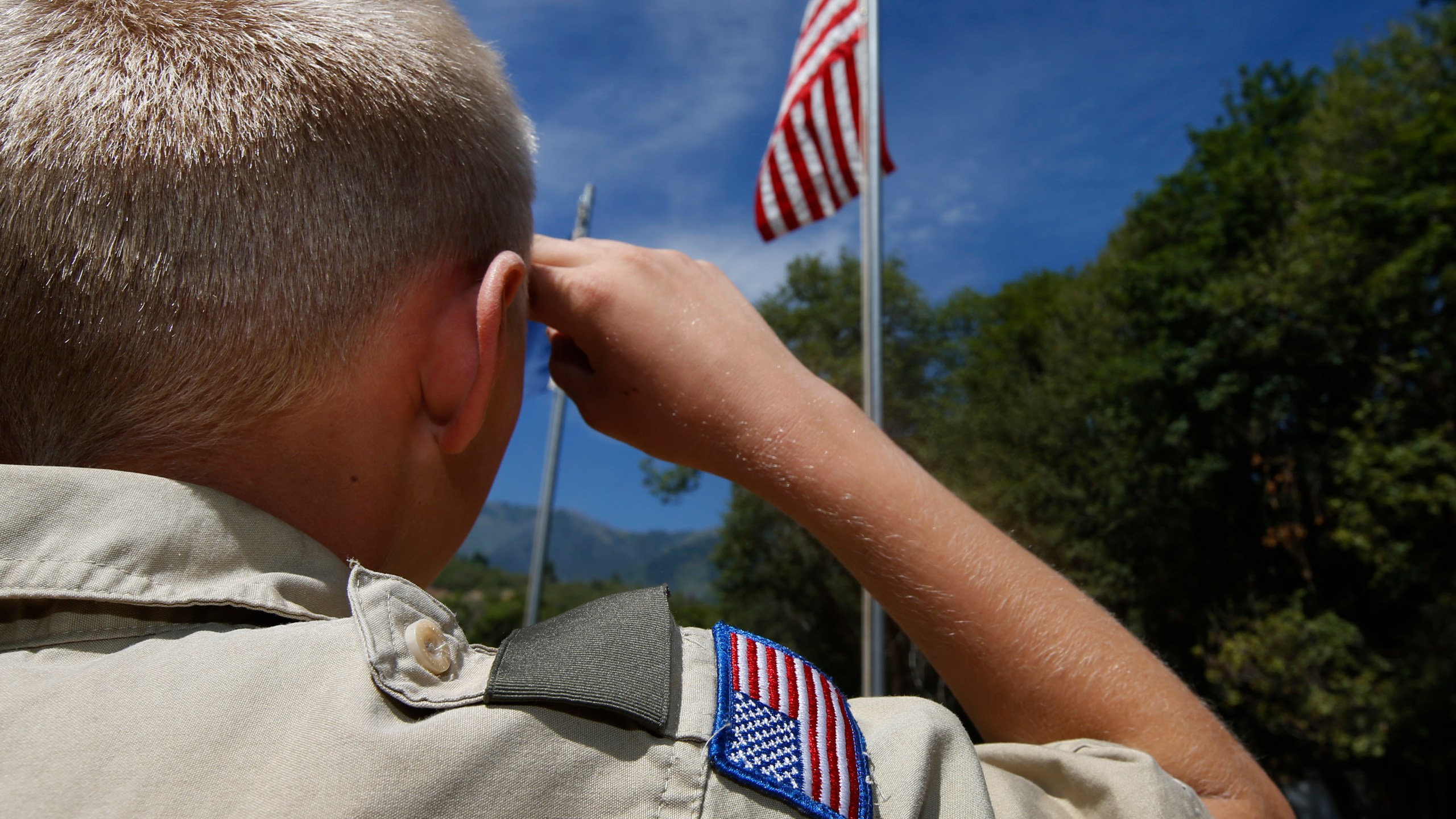 A Boy Scout salutes the American flag at camp Maple Dell on July 31, 2015, outside Payson, Utah. (Credit: George Frey/Getty Images)