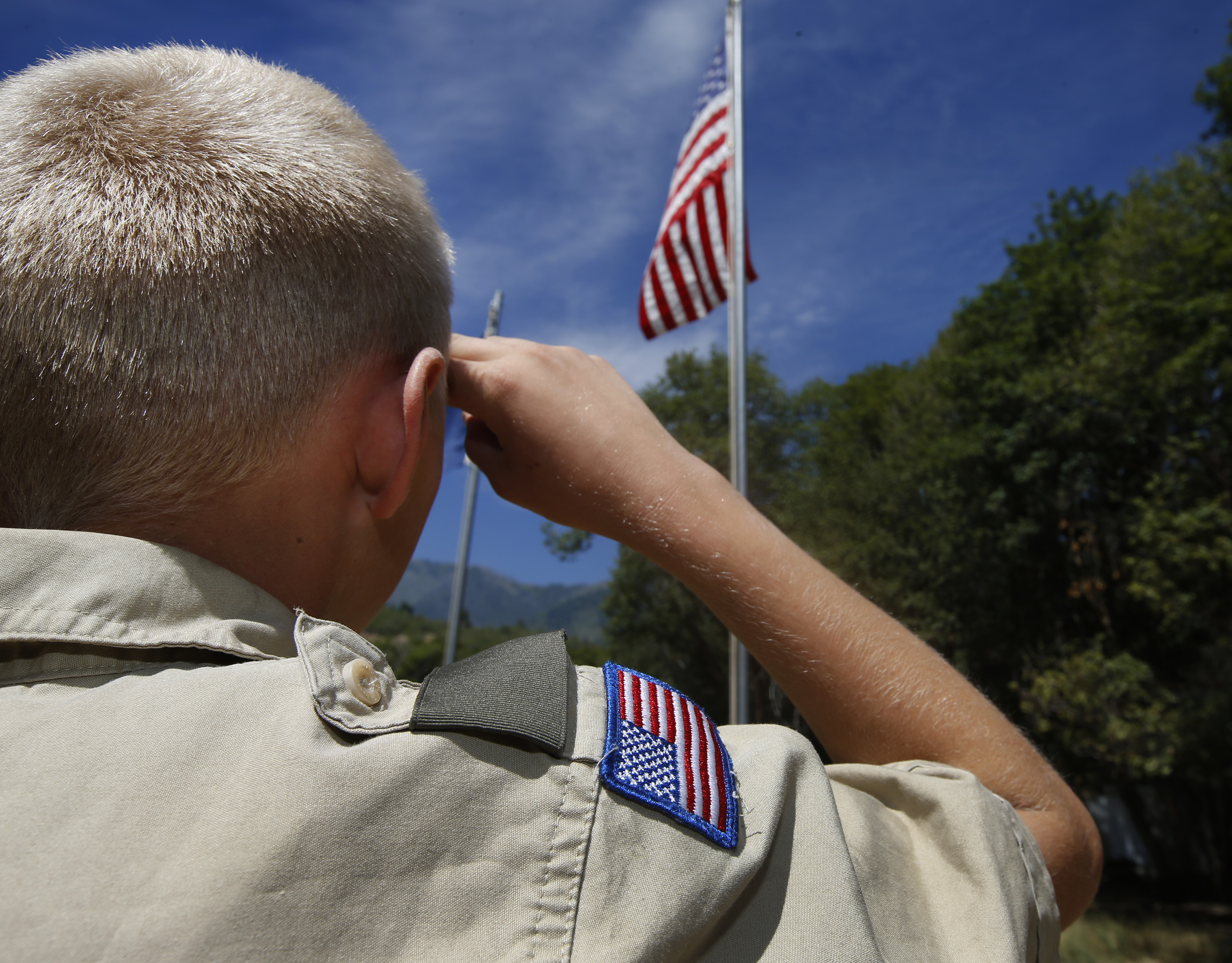 A Boy Scout salutes the American flag at camp Maple Dell on July 31, 2015, outside Payson, Utah. (Credit: George Frey/Getty Images)