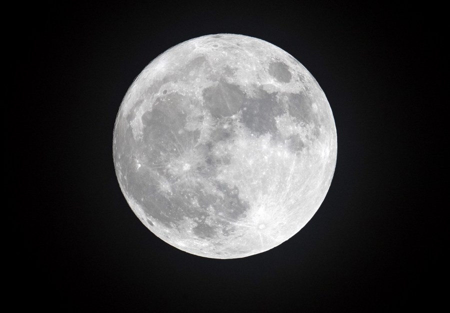 Clouds clear to allow a view of the final full moon of the year, a so-called 'cold moon', as it appears behind lights illuminating Penzance seafront on Dec.13, 2016, in Cornwall, England (Credit: Matt Cardy/Getty Images)