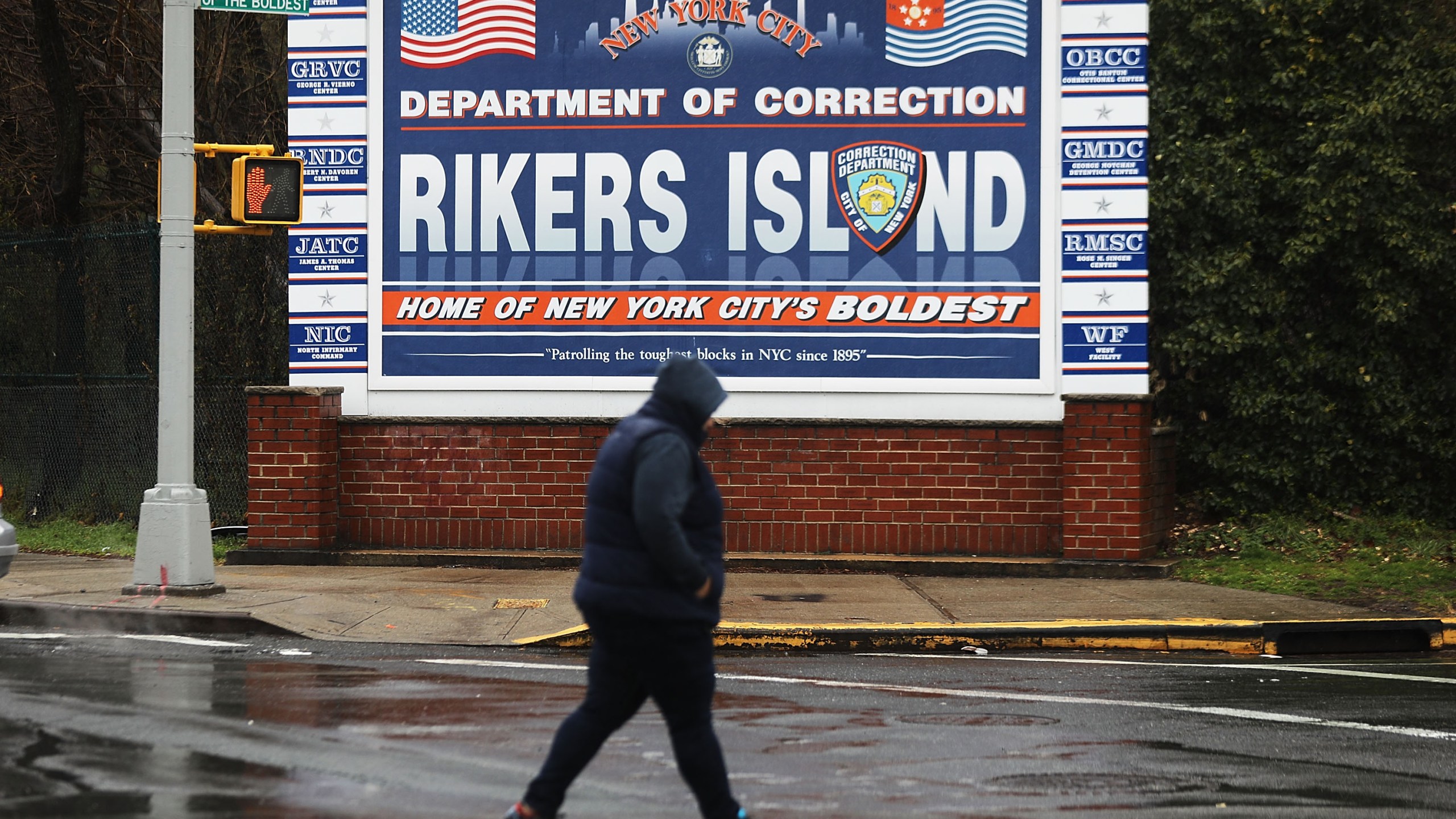 A woman walks by a sign at the entrance to Rikers Island on March 31, 2017 in New York City. (Credit: Spencer Platt/Getty Images)