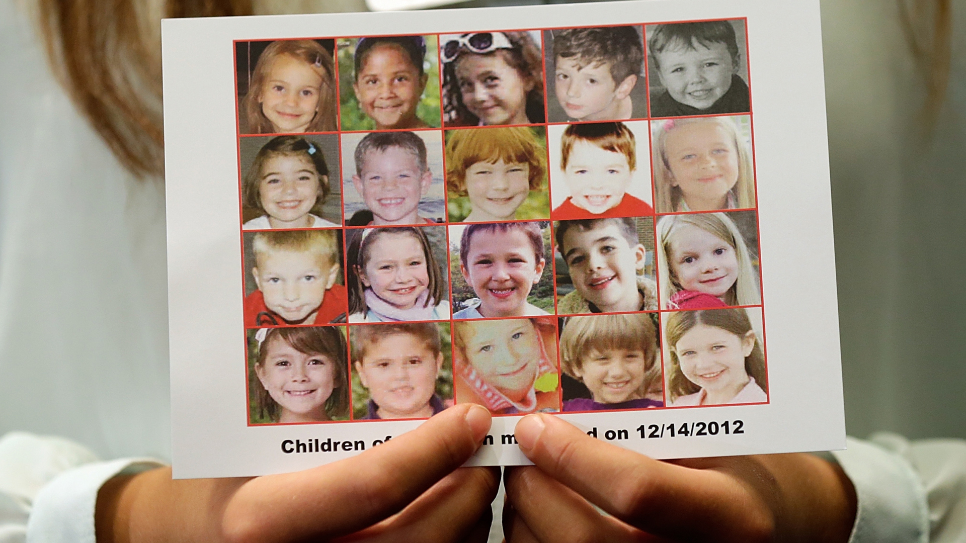 Kyra Murray holds a photo of the victims of the shooting at Sandy Hook Elementary School during a press conference at the U.S. Capitol on Sept. 18, 2013 in Washington, D.C. (Credit: Win McNamee/Getty Images)