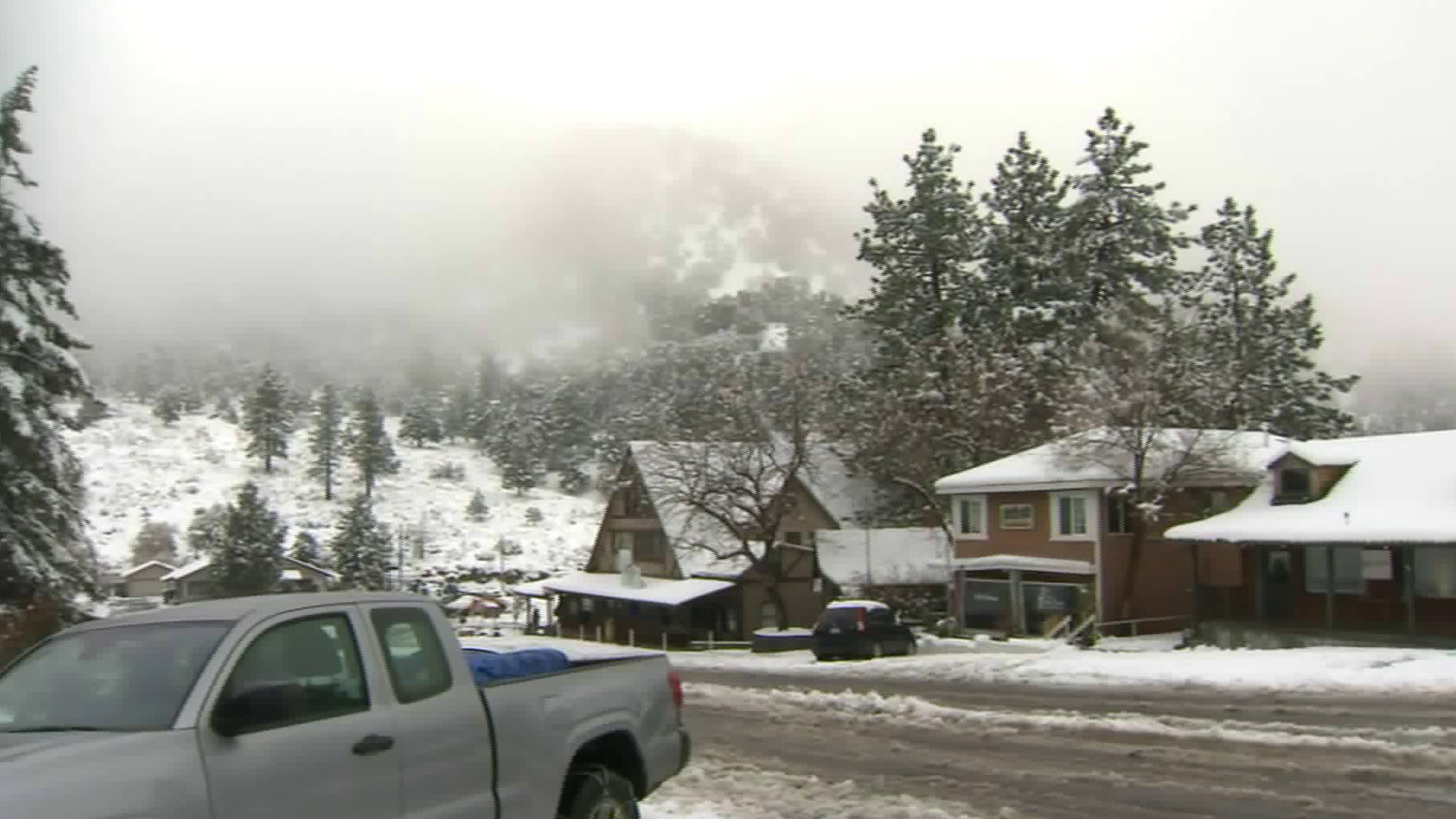 Snowfall blankets trees and buildings in Wrightwood on Dec. 23, 2019. (Credit: KTLA)