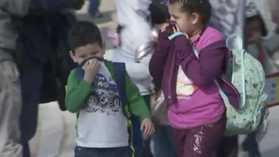 Students cover their noses after a Delta flight dropped fuel over the playground of Park Avenue Elementary School in Cudahy on Jan. 14, 2020. (Credit: KTLA)