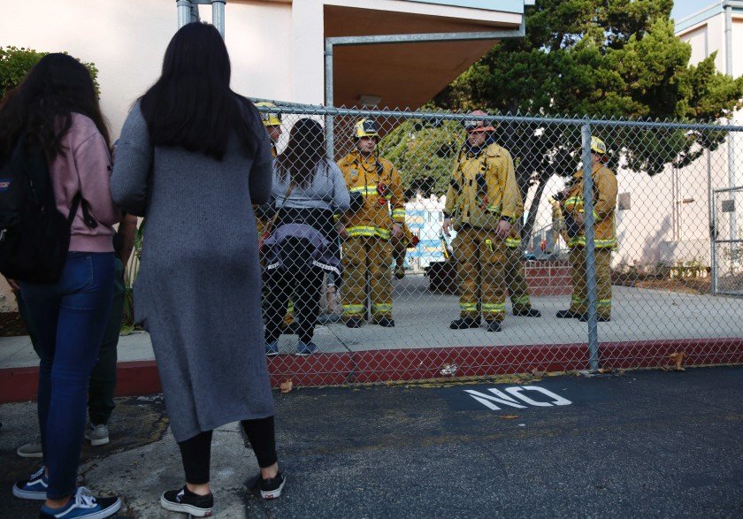 Parents wait outside Park Avenue Elementary School in Cudahy after an airplane returning to Los Angeles International Airport dropped what was believed to be engine fuel onto a school playground on Jan. 14, 2019. (Credit: Dania Maxwell/Los Angeles Times)