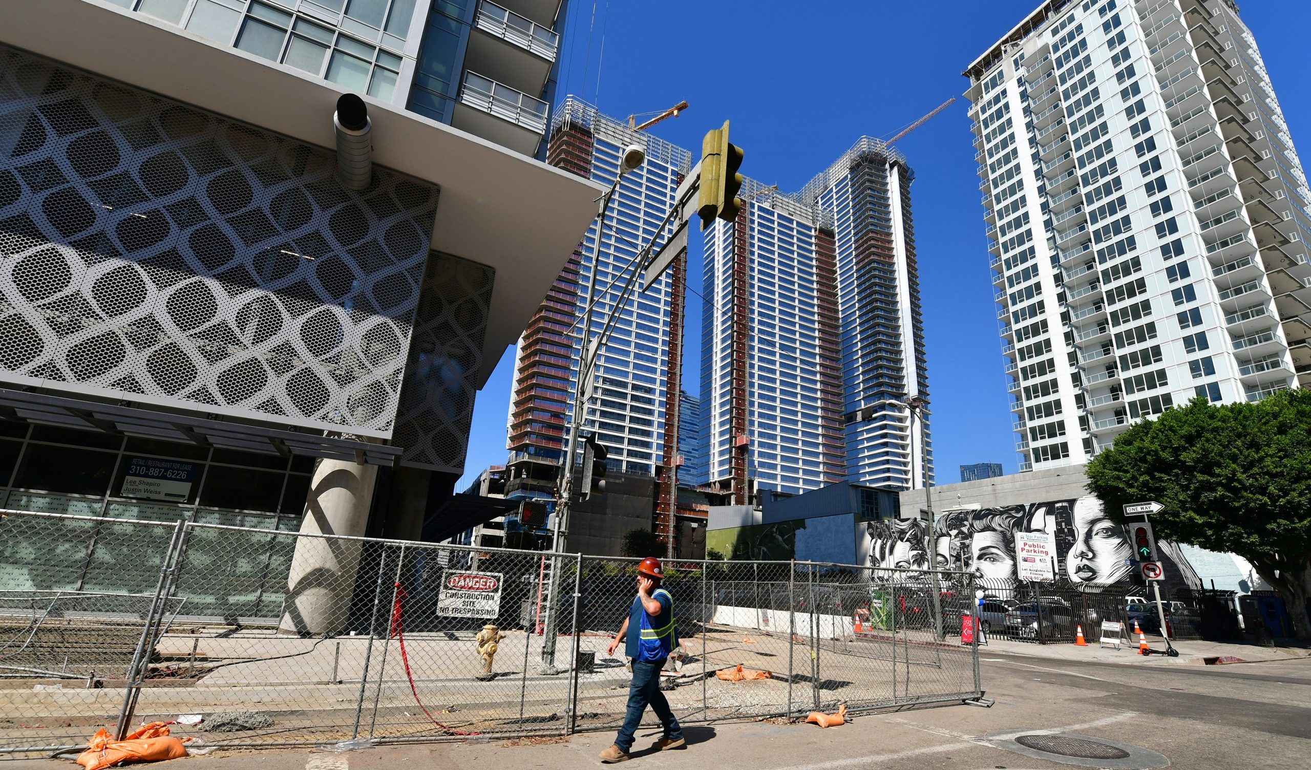 A worker walks amid luxury high-rise apartments under construction in Los Angeles on Oct. 8, 2019. (Credit: Frederic J. Brown / AFP / Getty Images)