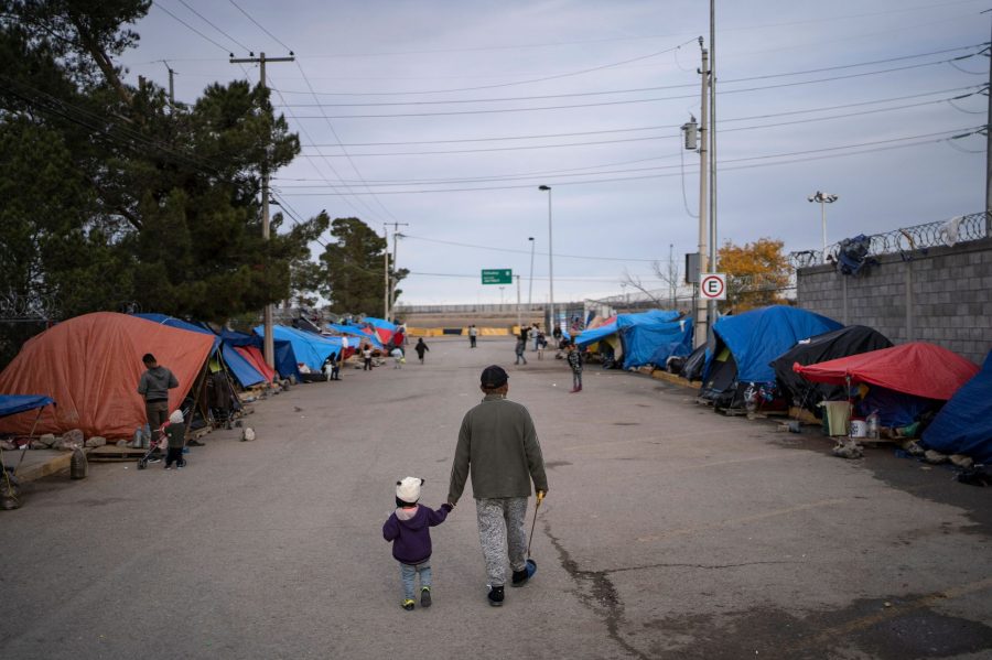 A man walks with his daughter at an asylum seekers camp near the Zaragoza bridge in Ciudad Juarez, Mexico, on Dec. 11, 2019. (Paul Ratje / AFP / Getty Images)