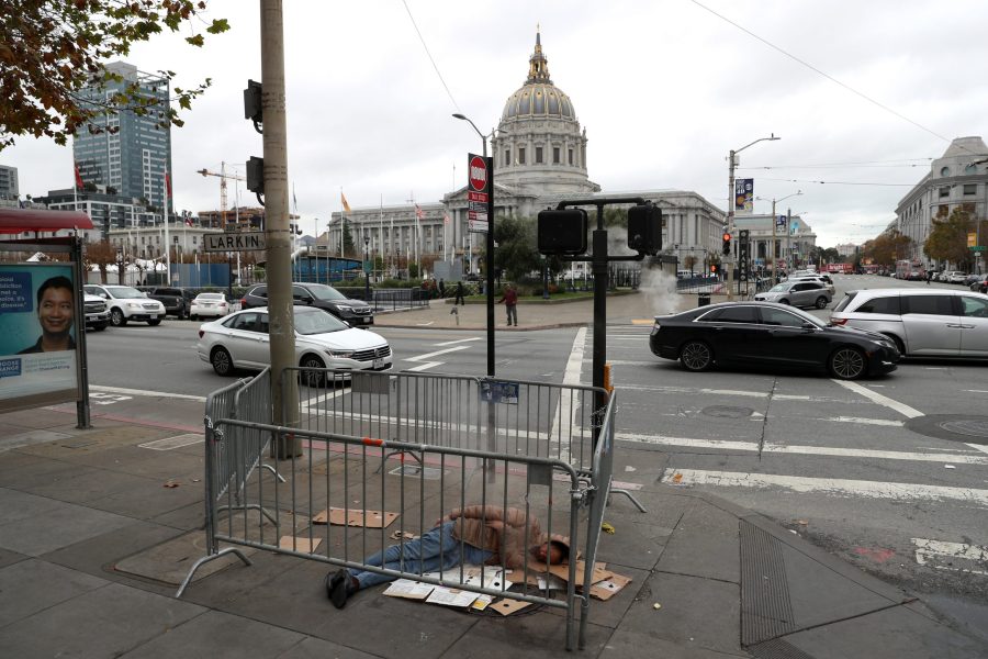 A homeless man sleeps on the sidewalk near San Francisco City Hall on Dec. 5, 2019, in San Francisco, California. (Credit: Justin Sullivan/Getty Images)