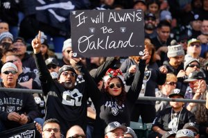 Fans in the stands hold signs during a game between the Oakland Raiders and the Jacksonville Jaguars in Oakland on Dec. 15, 2019. (Credit: Daniel Shirey / Getty Images)