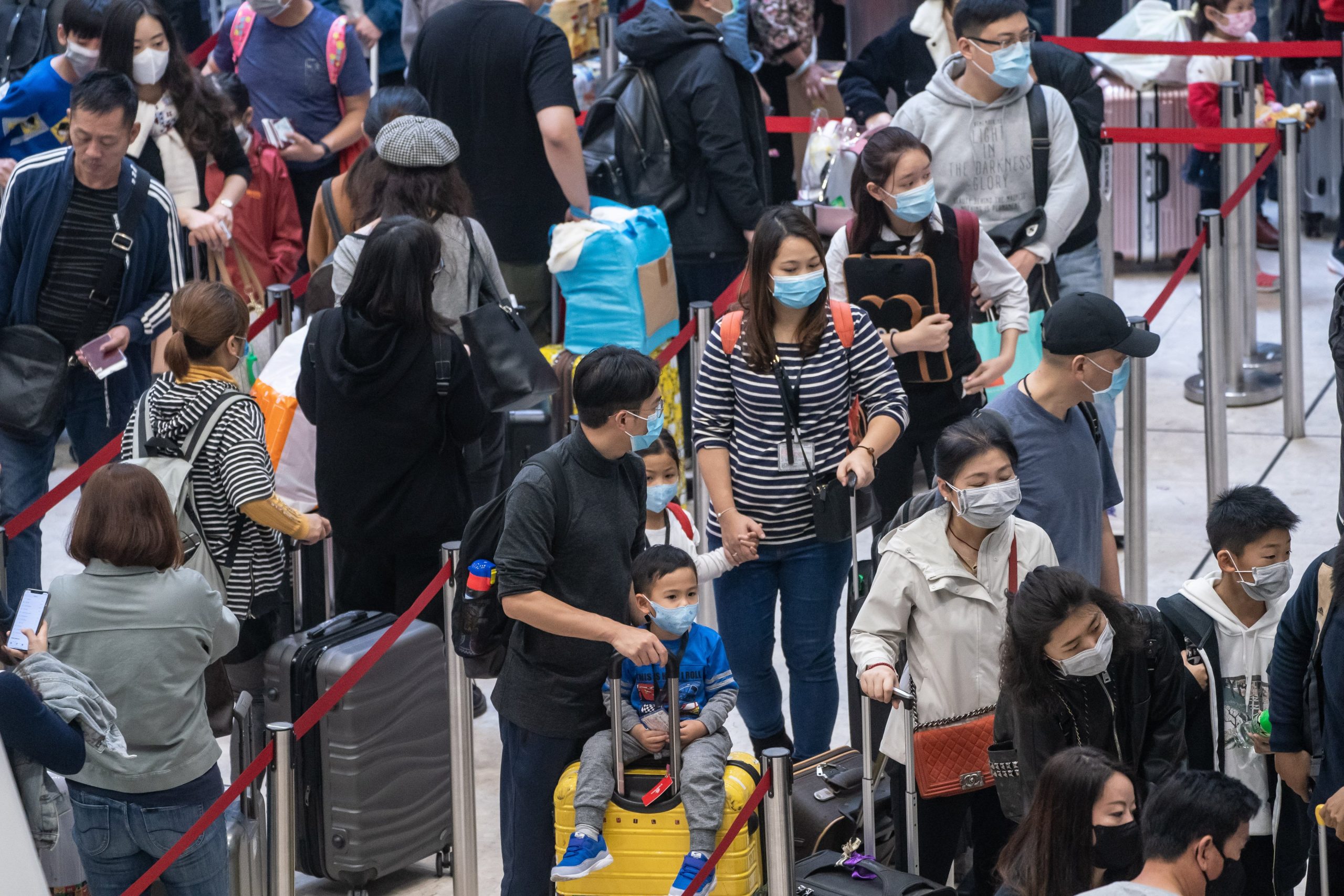 Travelers wearing face masks wait in line at the departure hall of West Kowloon Station on Jan. 23, 2020 in Hong Kong. (Credit: Anthony Kwan/Getty Images)