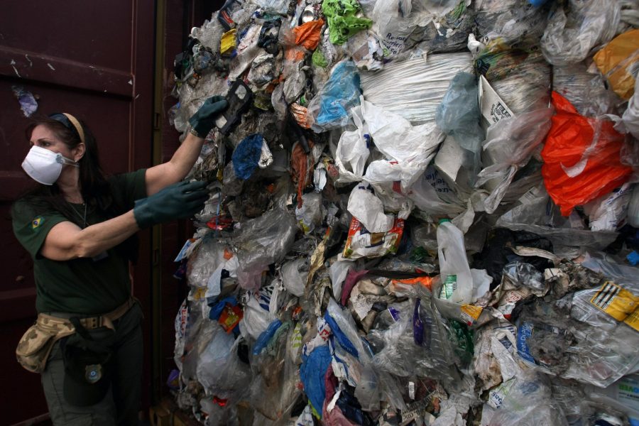 An agent inspects one of 41 containers carrying 1,400 tons of household waste shipped to Brazil from the United Kingdom on July 22, 2009. (Credit: Mauricio Lima /AFP via Getty Images)