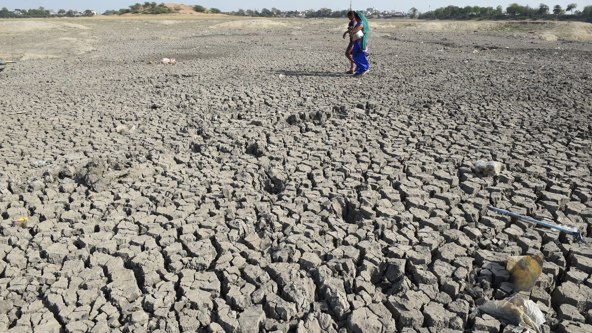 Indian women walk over the parched bed of Chandola Lake in Ahmedabad on March 22, 2019, on World Water Day. (Credit: SAM PANTHAKY/AFP via Getty Images)