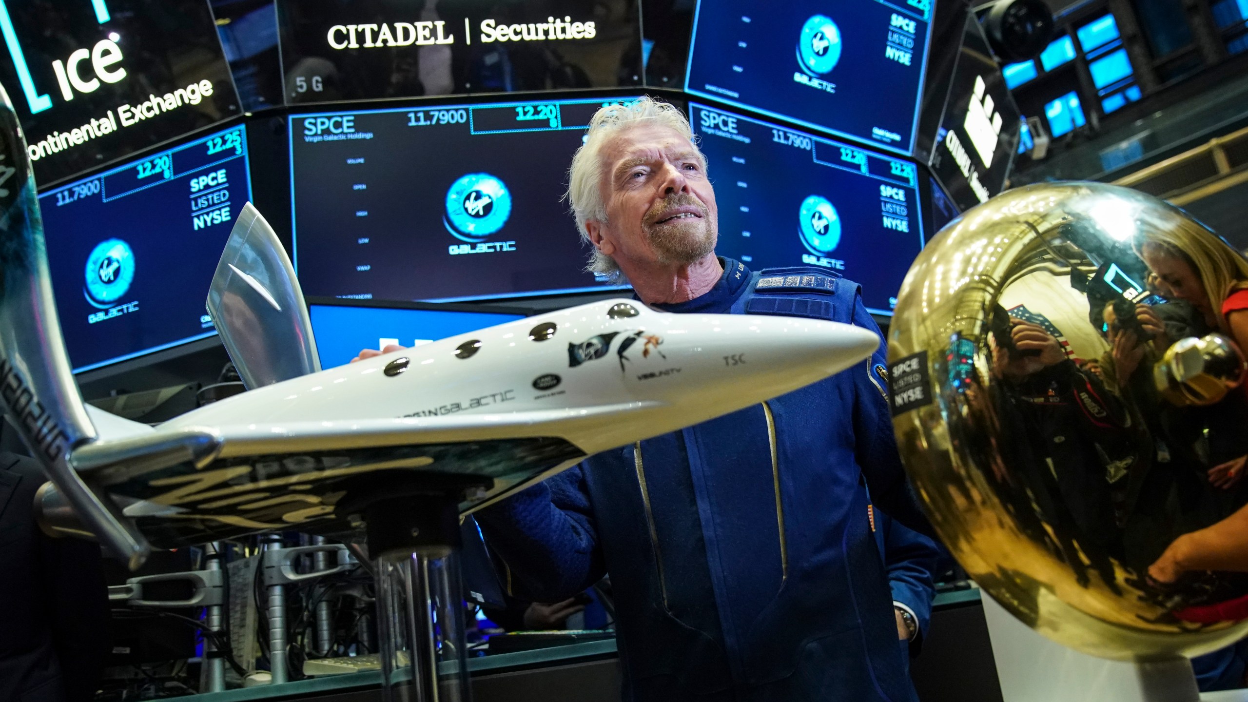 Sir Richard Branson, founder of Virgin Galactic, poses for photographs before ringing a ceremonial bell on the floor of the New York Stock Exchange on the company’s first day of trading shares, Oct. 28, 2019. (Credit: Drew Angerer / Getty Images)