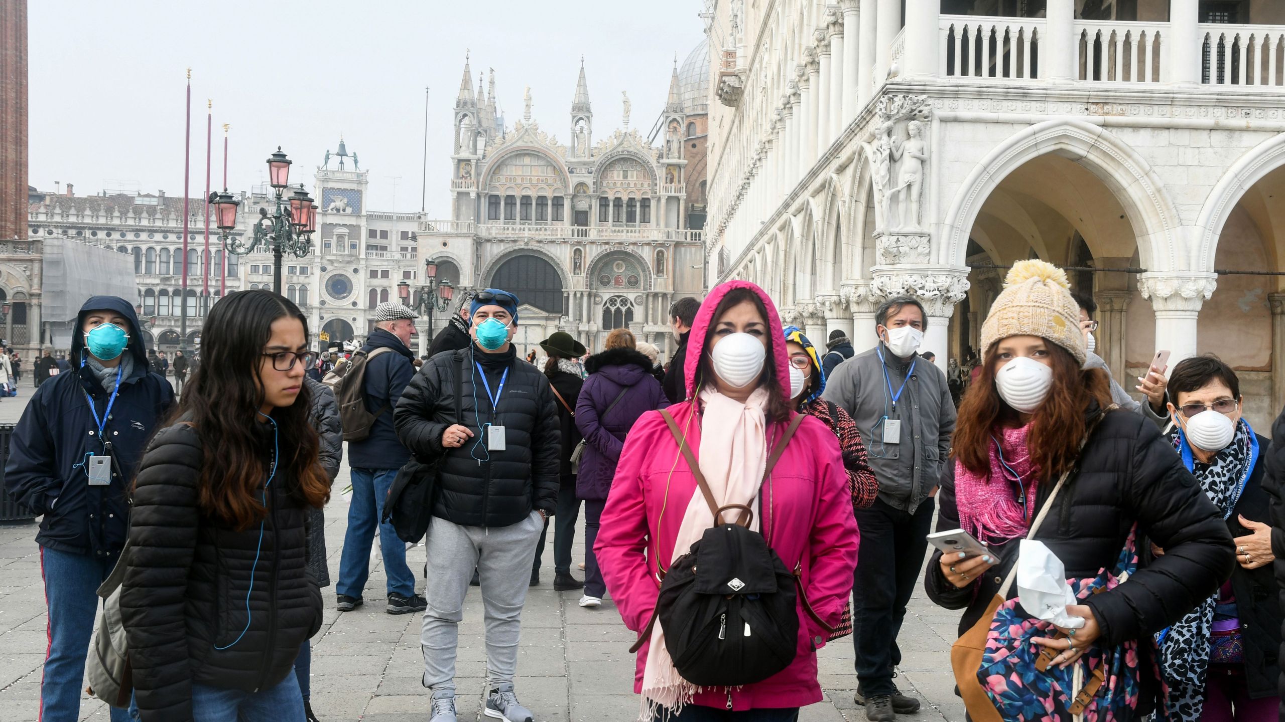 Tourists wearing protective masks visit Venice, Italy on Feb. 25, 2020, during the usual period of the Carnival festivities which have been cancelled following an outbreak of the COVID-19 novel coronavirus in northern Italy. (ANDREA PATTARO/AFP via Getty Images)