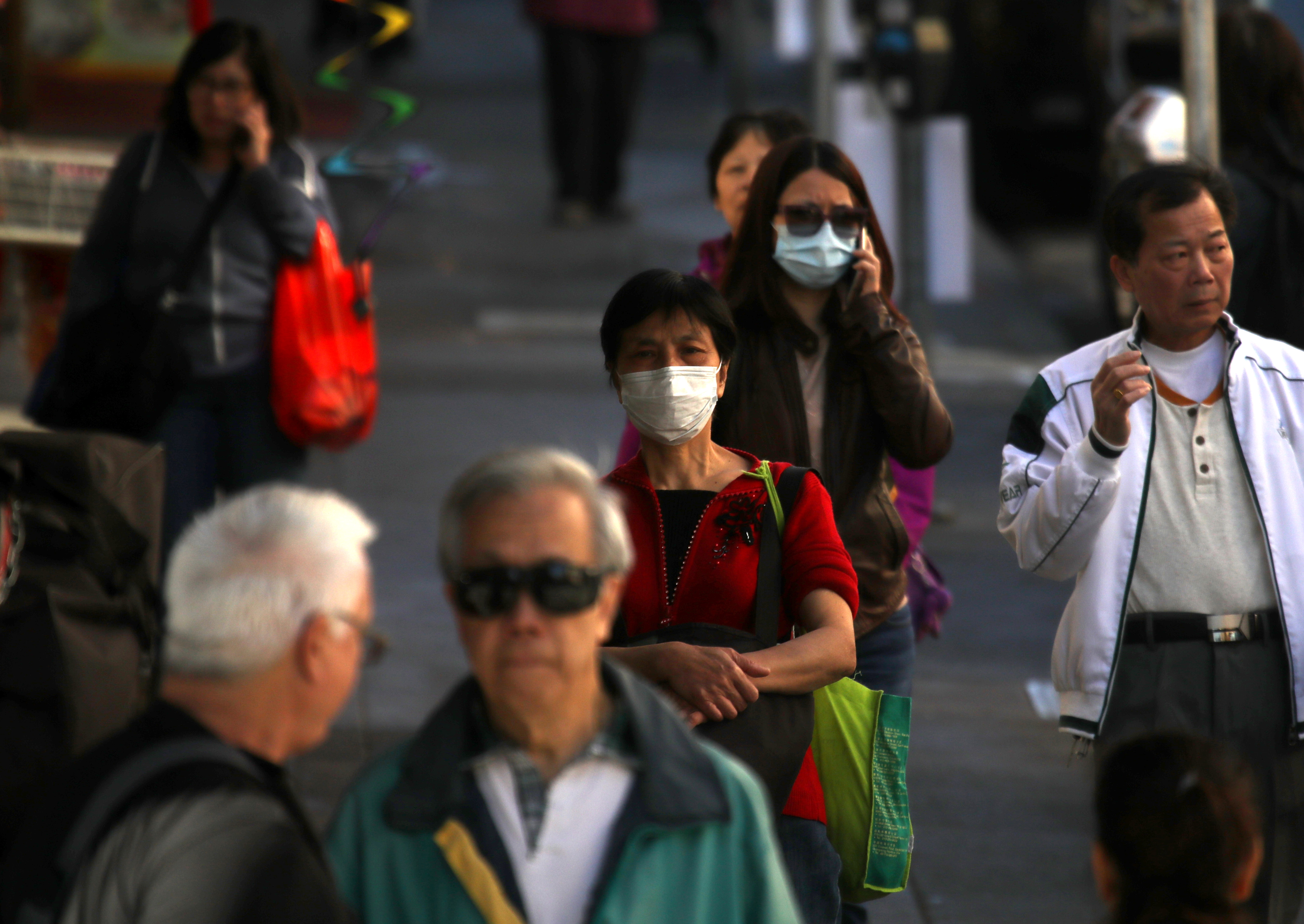 People wear surgical masks as they walk along Grant Avenue in San Francisco’s Chinatown on Feb. 26, 2020. (Credit: Justin Sullivan / Getty Images)