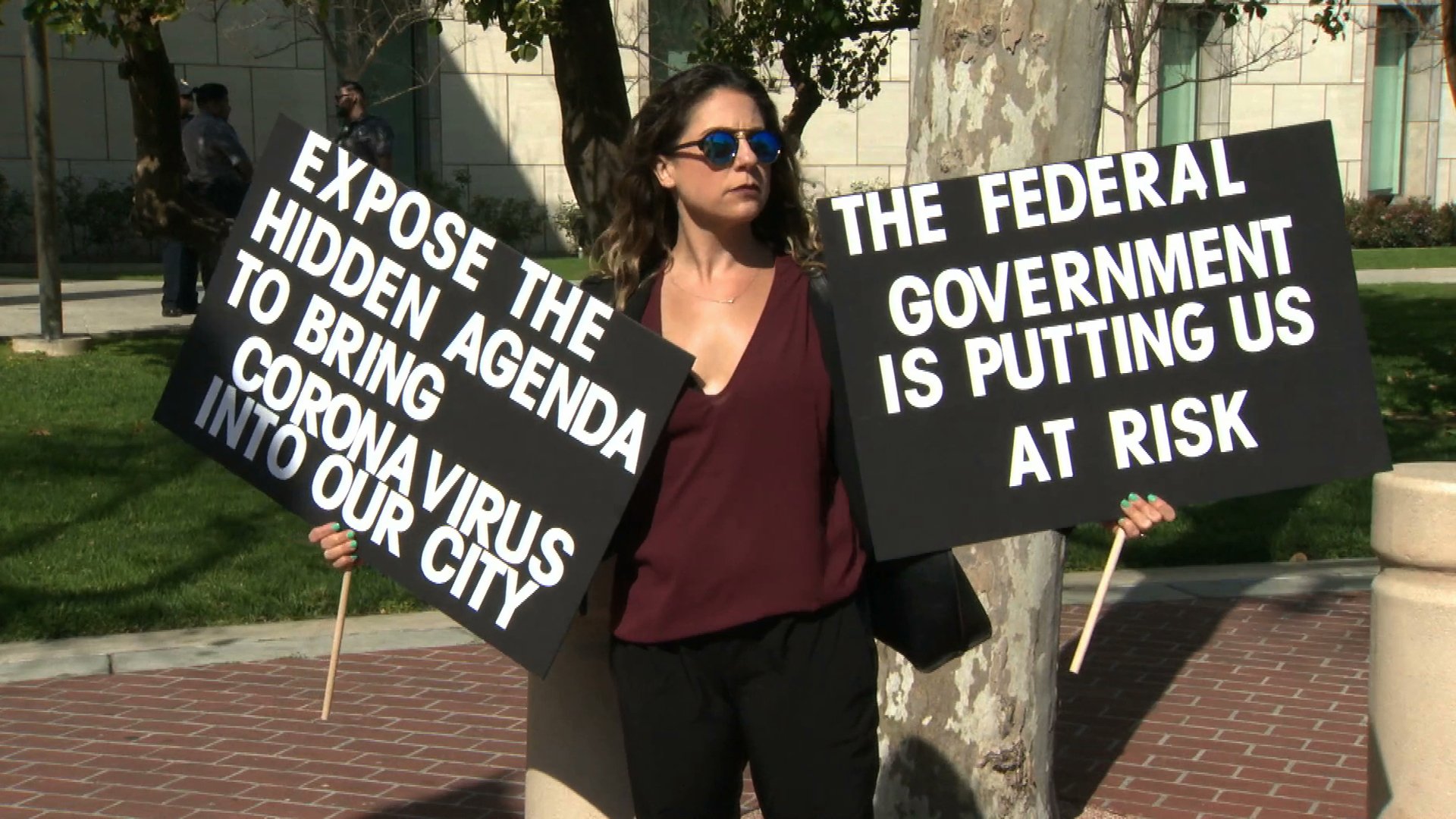 A woman demonstrates against a proposal to quarantine coronavirus patients at a Costa Mesa facility on Feb. 24, 2020. (Credit: KTLA(