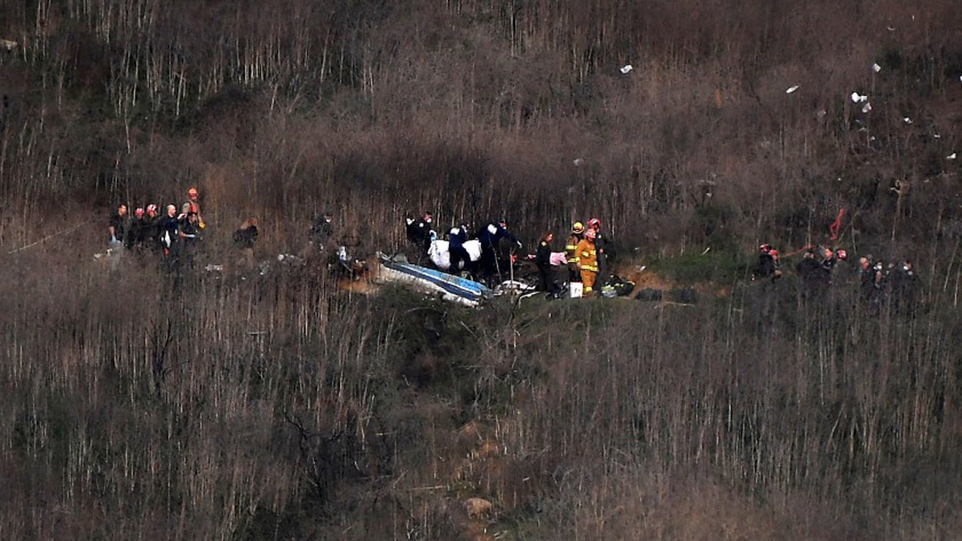 Officials remove a body from the wreckage in Calabasas where Kobe Bryant and his daughter Gianna were among nine dead in a helicopter crash. (Christina House / Los Angeles Times)