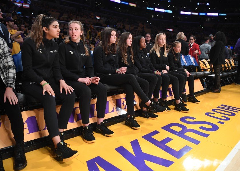 Members of Team Mamba, the girls’ basketball team Kobe Bryant coached, sit courtside before a pregame ceremony at Staples Center honoring the Lakers legend and the eight others who lost their lives in a helicopter crash on Jan. 26, 2020.(Credit: Wally Skalij / Los Angeles Times)