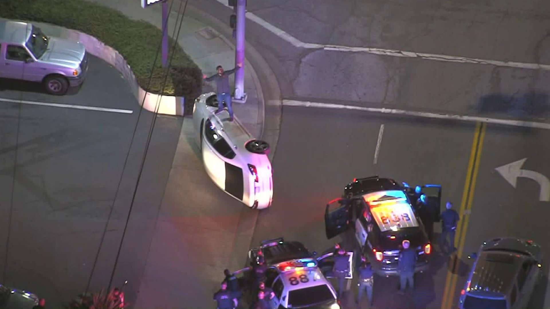 Pursuit suspect climbs onto overturned car following a chase in Downey on Jan. 31, 2020. (Credit: KTLA)