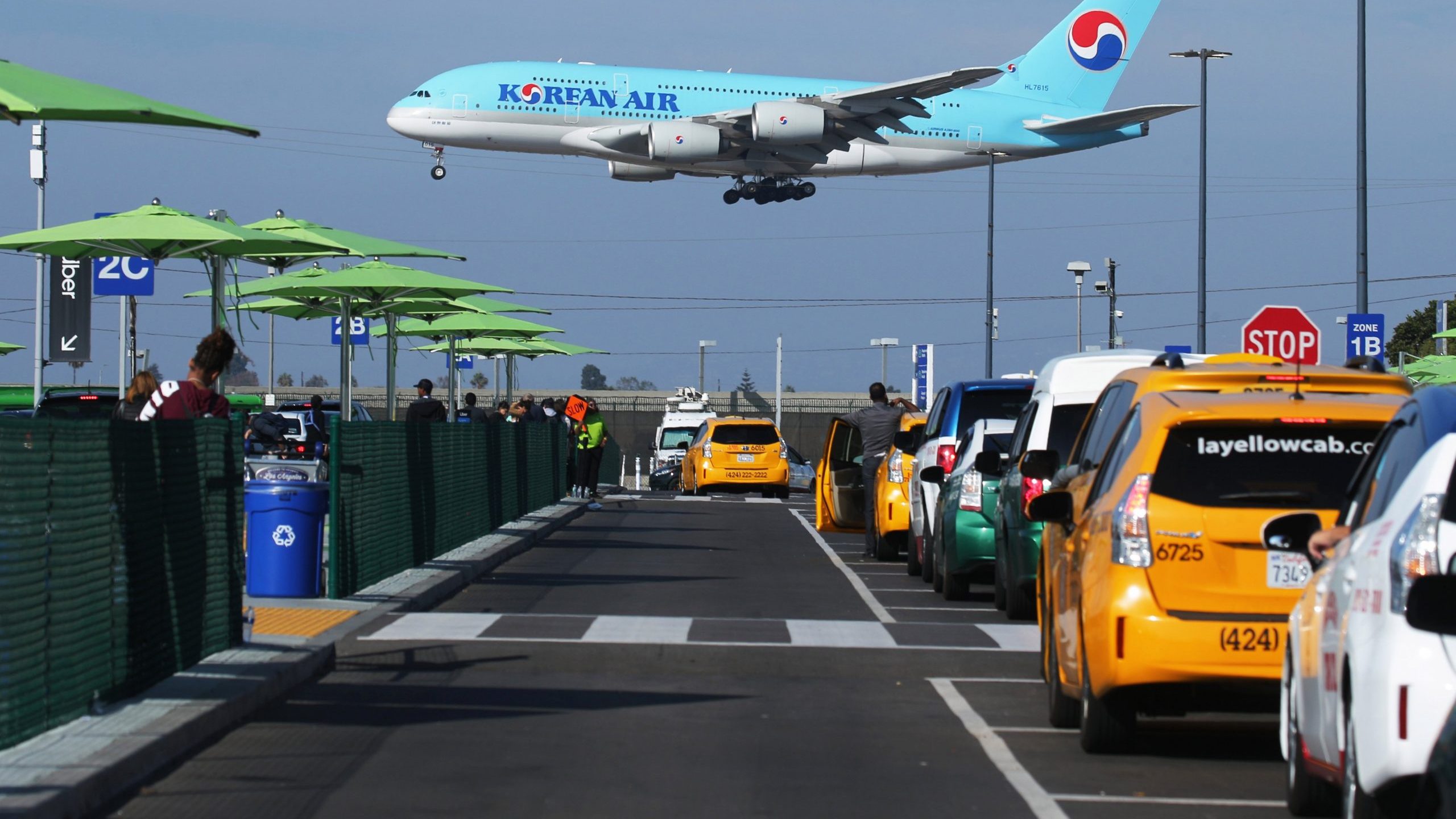 A Korean Air plane lands as taxis are lined up at the new 'LAX-it' ride-hail passenger pickup lot at Los Angeles International Airport on Nov. 6, 2019. (Credit: Mario Tama/Getty Images)