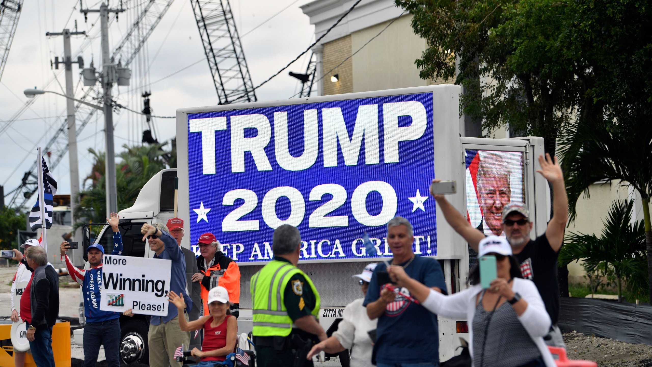 Supporters wave as Donald Trump's motorcade drives past near Mar-a-Lago in West Palm Beach, Florida on Dec. 24, 2019. (Credit: NICHOLAS KAMM/AFP via Getty Images)