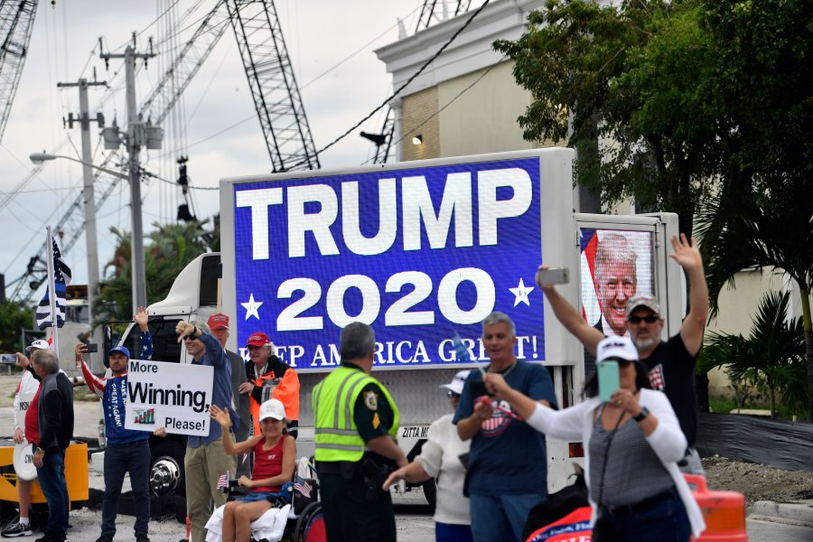 Supporters wave as Donald Trump's motorcade drives past near Mar-a-Lago in West Palm Beach, Florida on Dec. 24, 2019. (Credit: NICHOLAS KAMM/AFP via Getty Images)