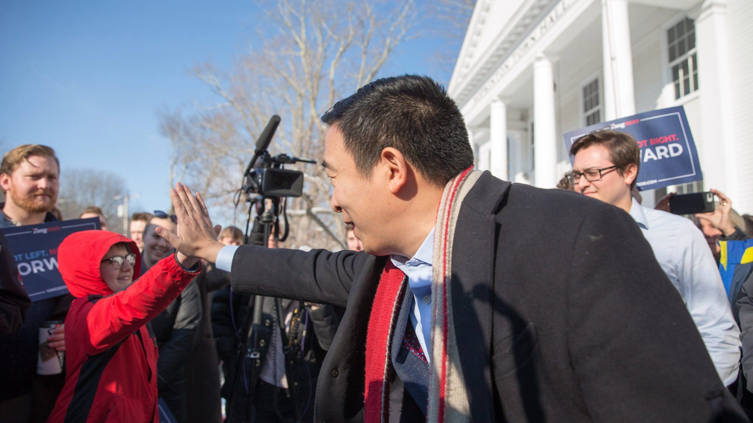 Democratic presidential candidate Andrew Yang high-fives a boy outside of Hopkinton Town Hall following a campaign event on Feb. 9, 2020, in New Hampshire. (Credit: Scott Eisen/Getty Images)