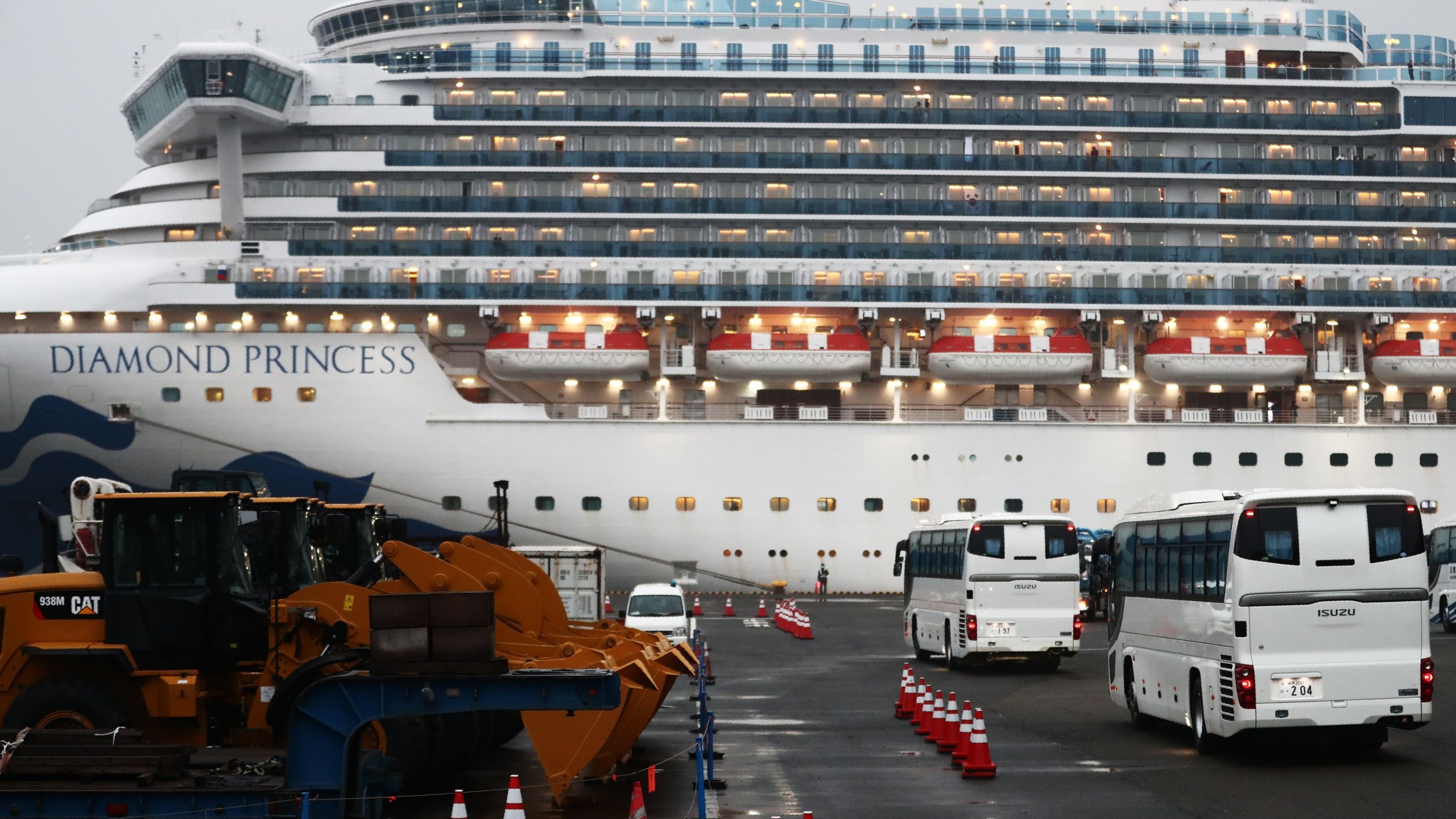 Two buses arrive next to the Diamond Princess cruise ship, with people quarantined onboard due to fears of the new coronavirus, at the Daikaku Pier Cruise Terminal in Yokohama port on Feb.16, 2020.(Credit: BEHROUZ MEHRI/AFP via Getty Images)