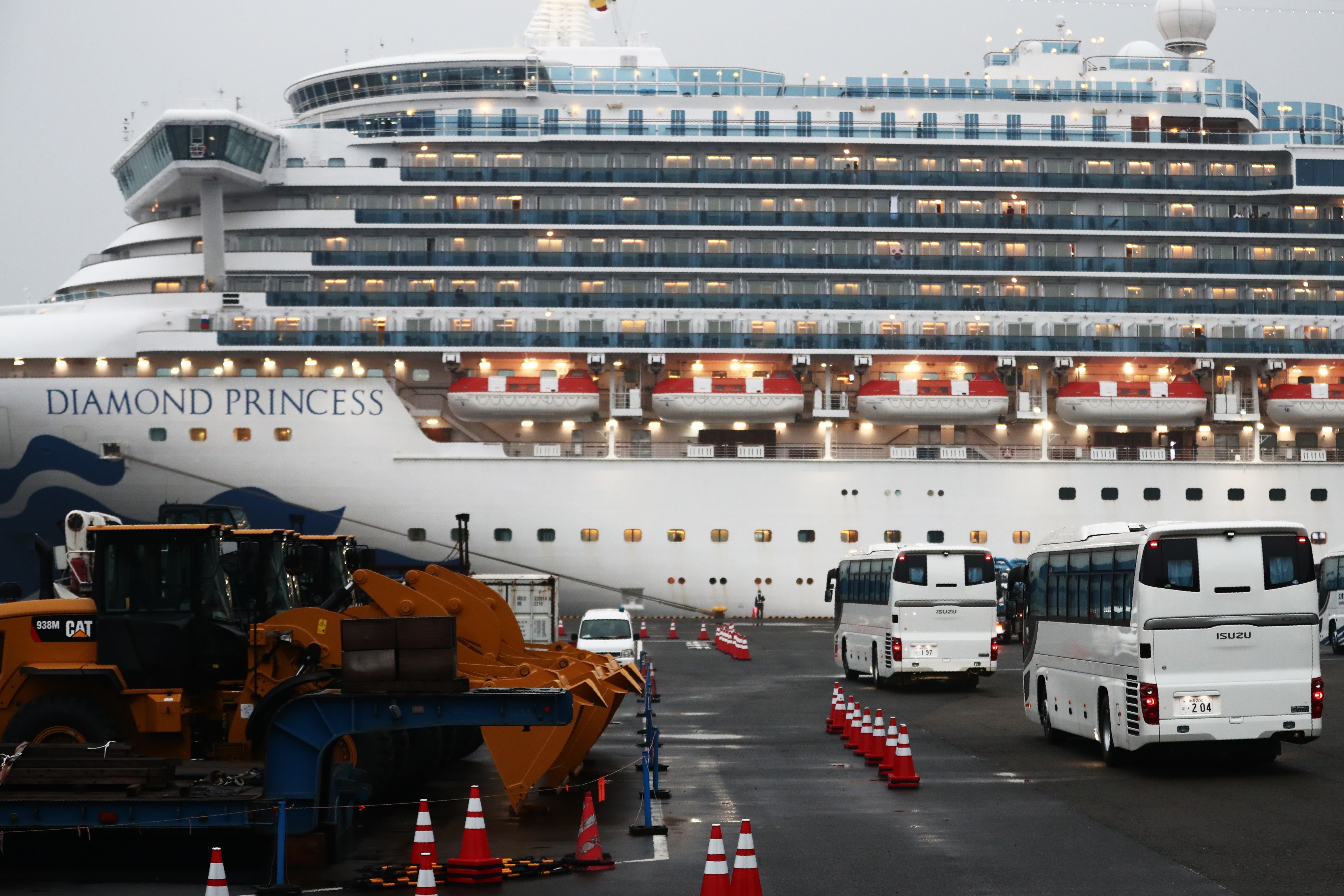 Two buses arrive next to the Diamond Princess cruise ship, with people quarantined onboard due to fears of the new coronavirus, at the Daikaku Pier Cruise Terminal in Yokohama port on Feb.16, 2020.(Credit: BEHROUZ MEHRI/AFP via Getty Images)