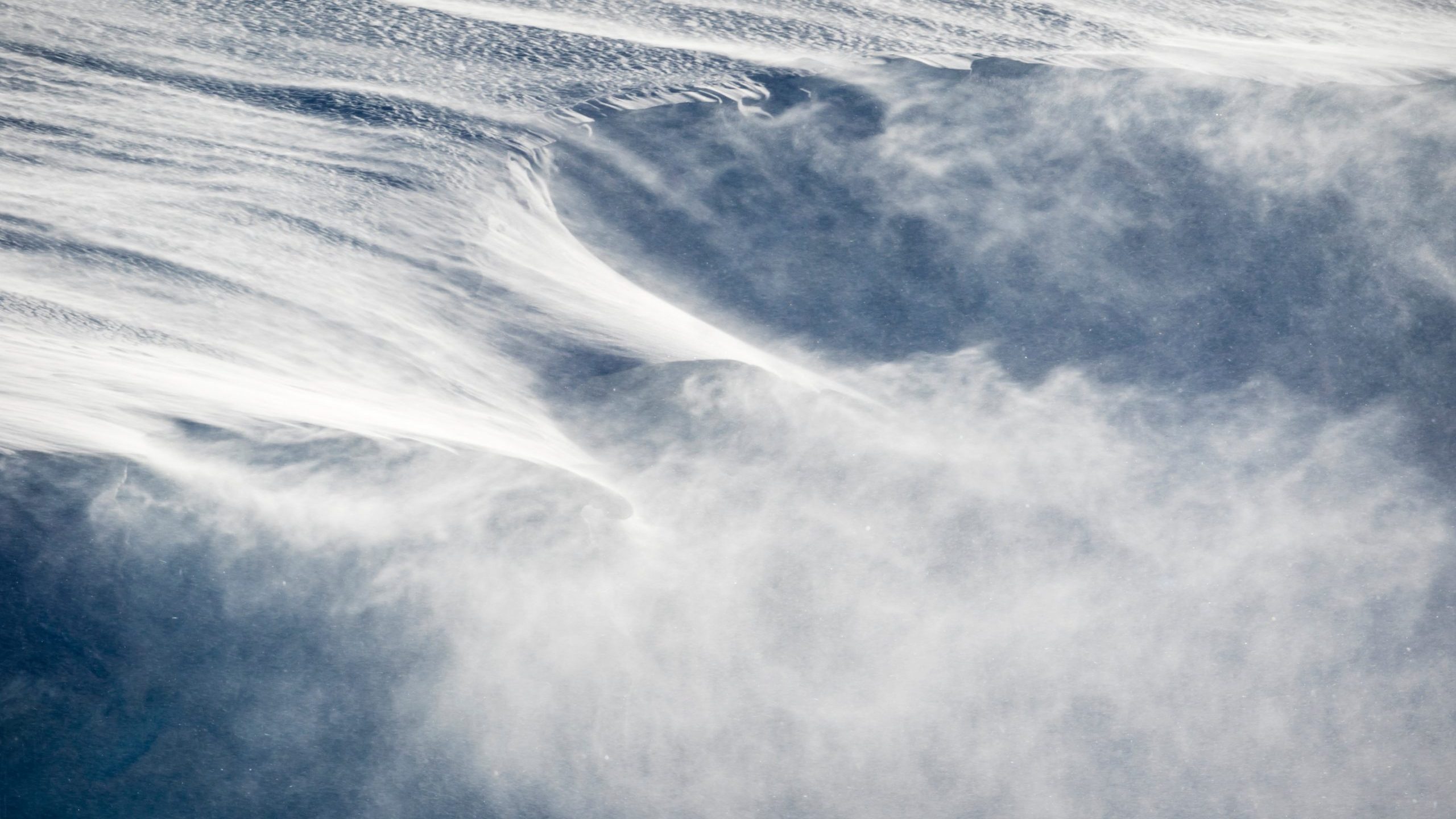 Strong wind blows snow from an icy slope in this file photo. (Credit: Getty Images)