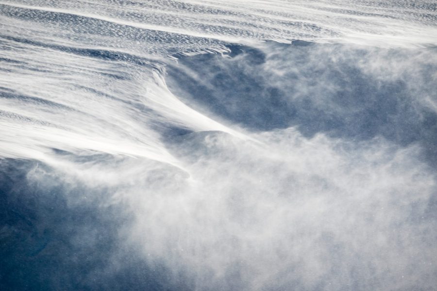 Strong wind blows snow from an icy slope in this file photo. (Credit: Getty Images)