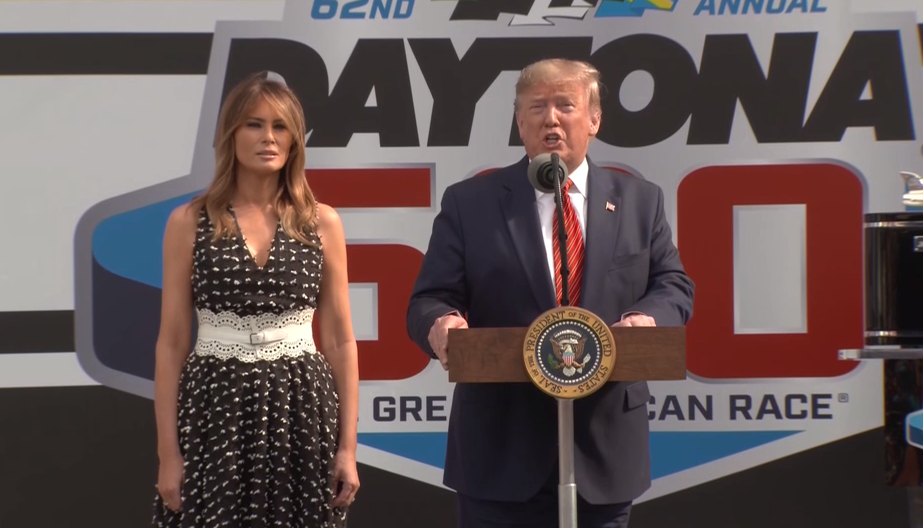 Donald Trump, standing beside Melania Trump, addresses the crowd at Daytona 500 in Florida on Feb. 16, 2020. (Credit: CNN)