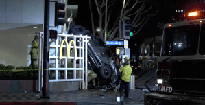 A Jeep landed against a building after plunging off a six-story parking structure across the street on Feb. 23, 2020. (Credit: Loudlabs)