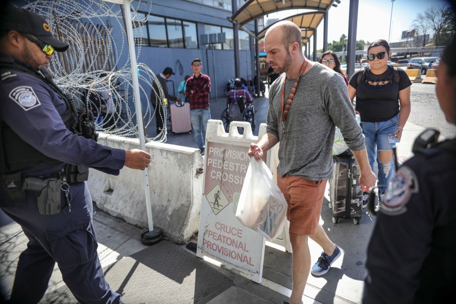 An Immigration and Customs Enforcement (ICE) agent check pedestrians' documentation at the San Ysidro Port of Entry on Oct. 2, 2019 in San Ysidro, California. (SANDY HUFFAKER/AFP via Getty Images)