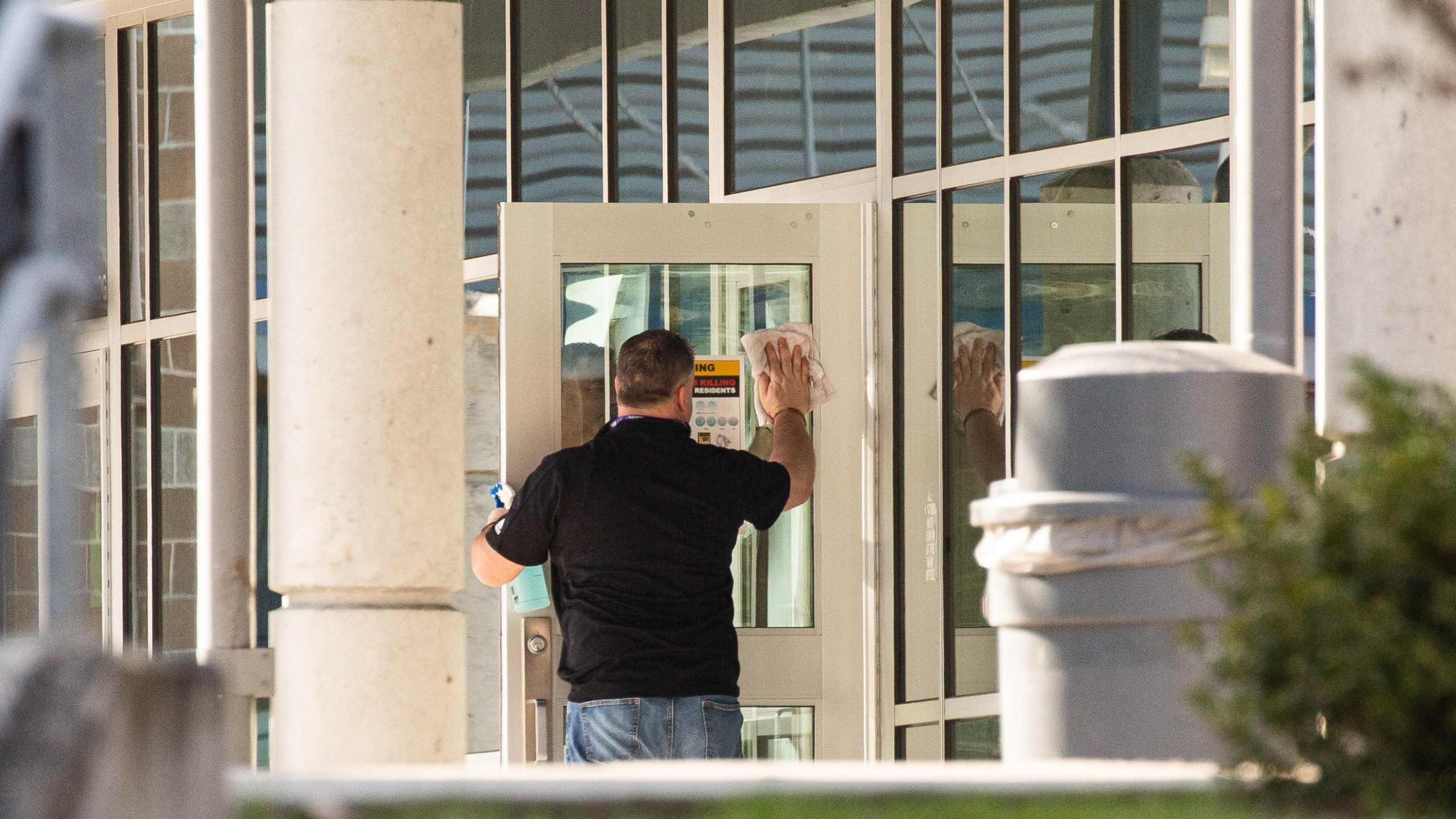 A staff member cleans a door at Bothell High School on Feb. 27, 2020, in Bothell, Washington. School district officials decided to close the school for disinfecting after a family member of a school staffer was quarantined for possible coronavirus. (David Ryder/Getty Images)