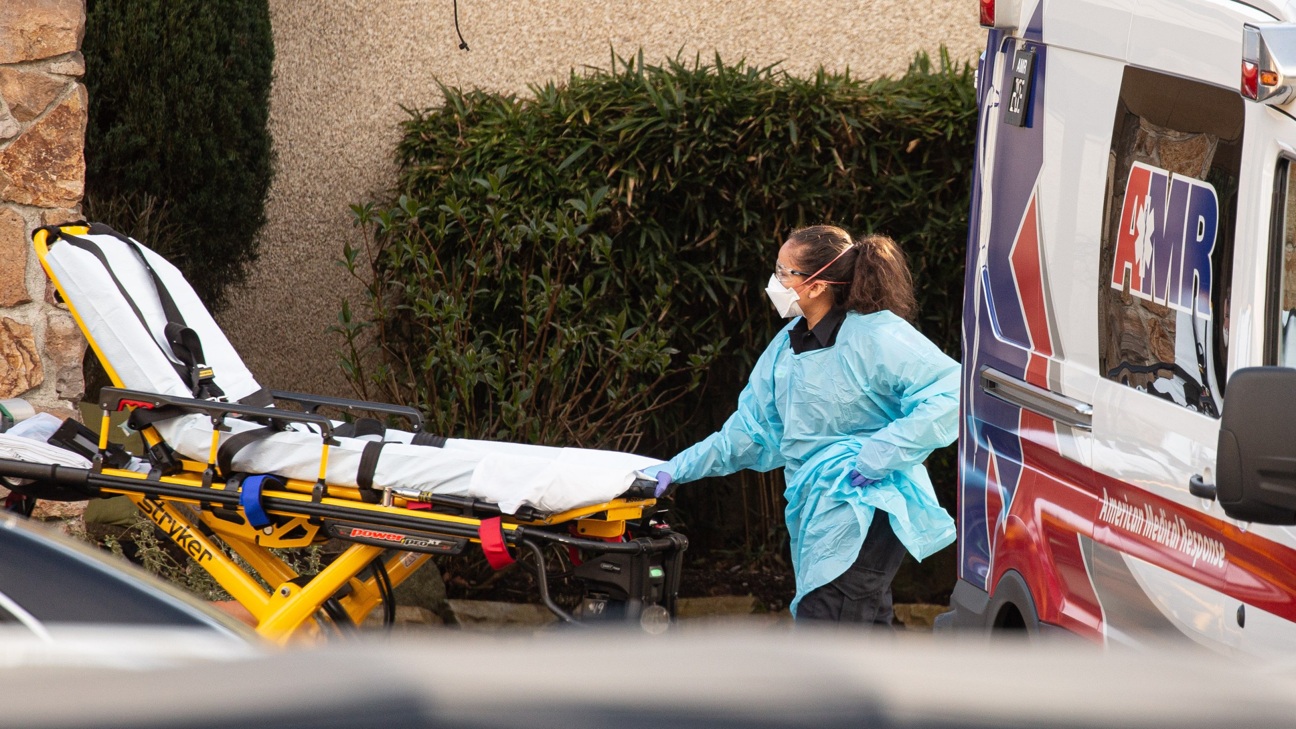 A health care worker prepares to transport a patient on a stretcher into an ambulance at Life Care Center of Kirkland on Feb. 29, 2020, in Kirkland, Washington. (David Ryder/Getty Images)